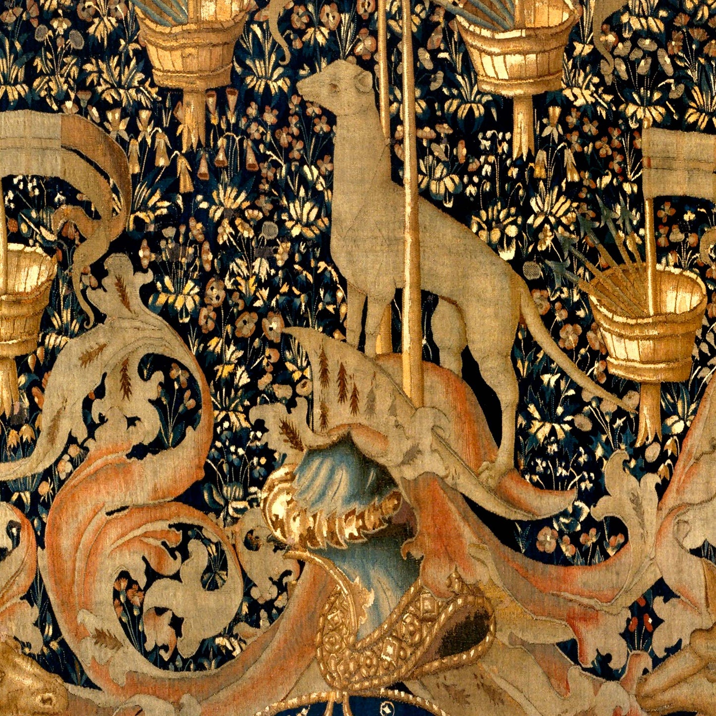 Stylized dog or hound beside heraldic crest and decorative foliage in the tapestry.