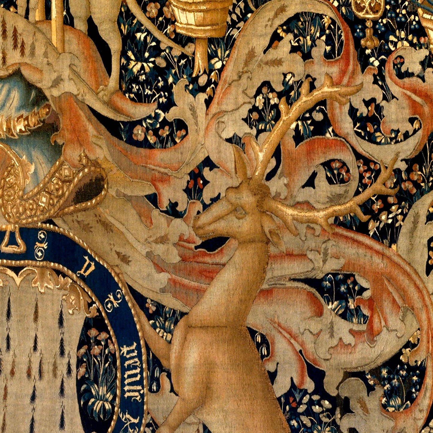 Detailed view of a stag with gilded antlers and swirling foliate scrolls behind.