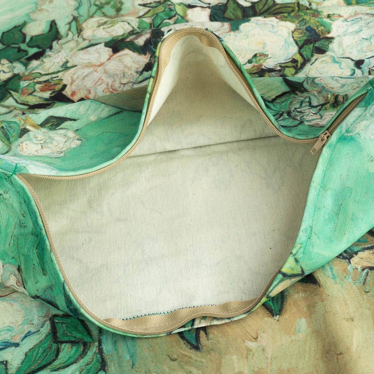Close-up view of open pillow cover revealing inside lining and canvas texture with floral print.