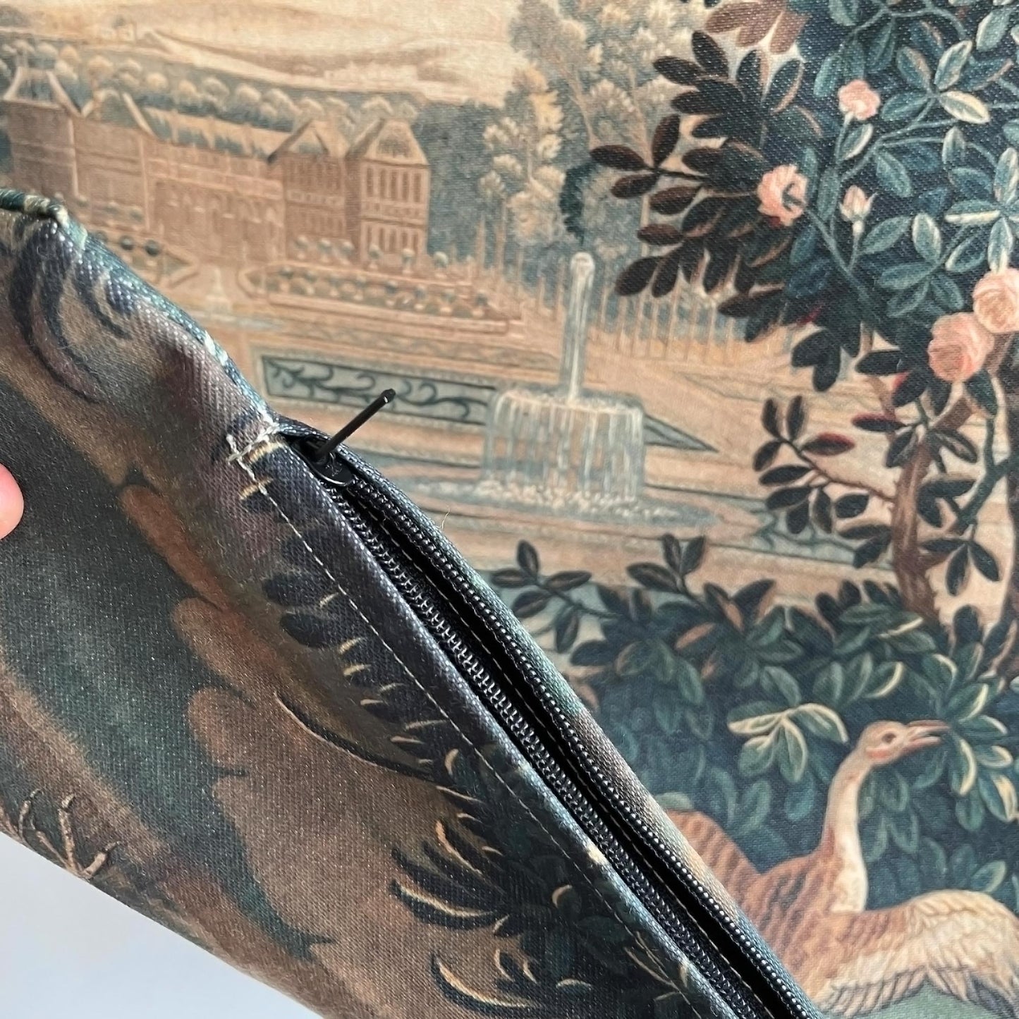 Detail of the black zipper in the Verdure with Castle and Garden throw pillow cover