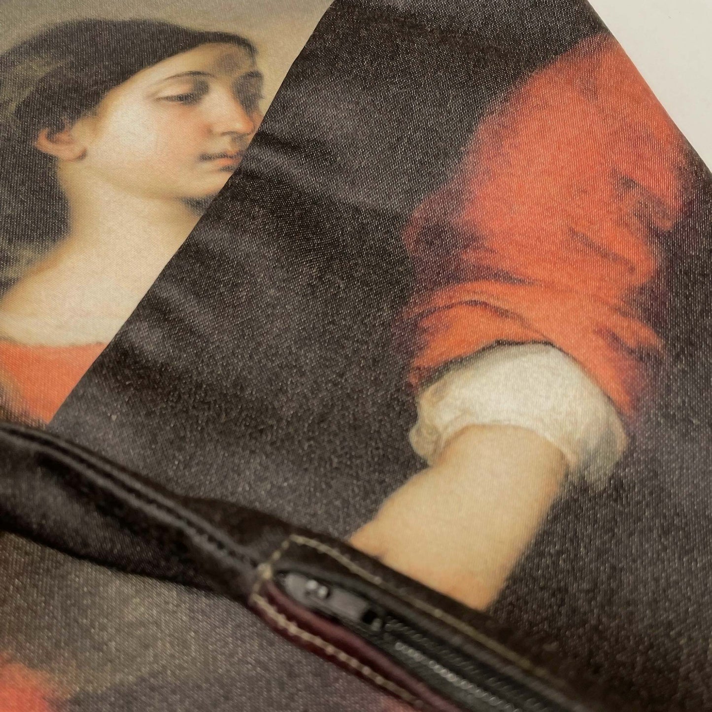 Close-up of Virgin and Child throw pillow cover folded, showing the black zipper and the two sides printed.