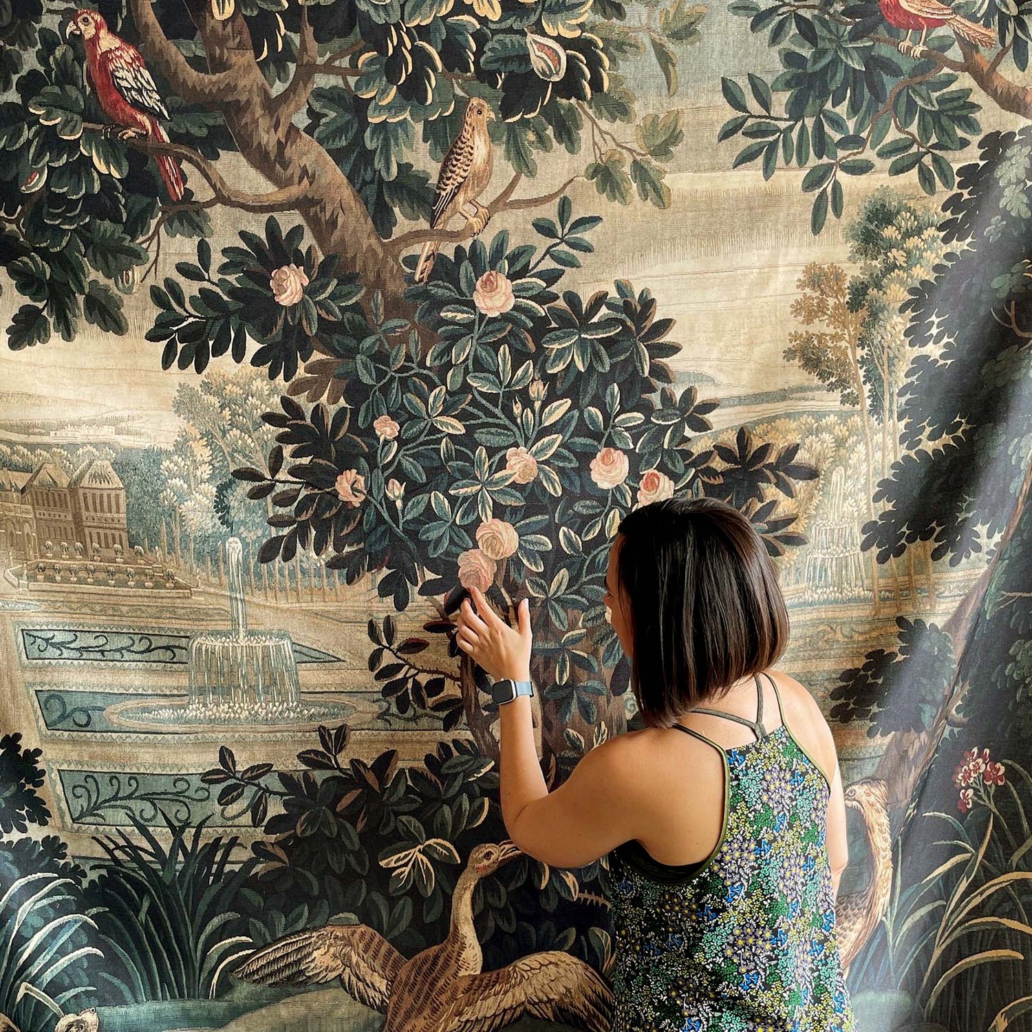 Woman checking large Verdure tapestry