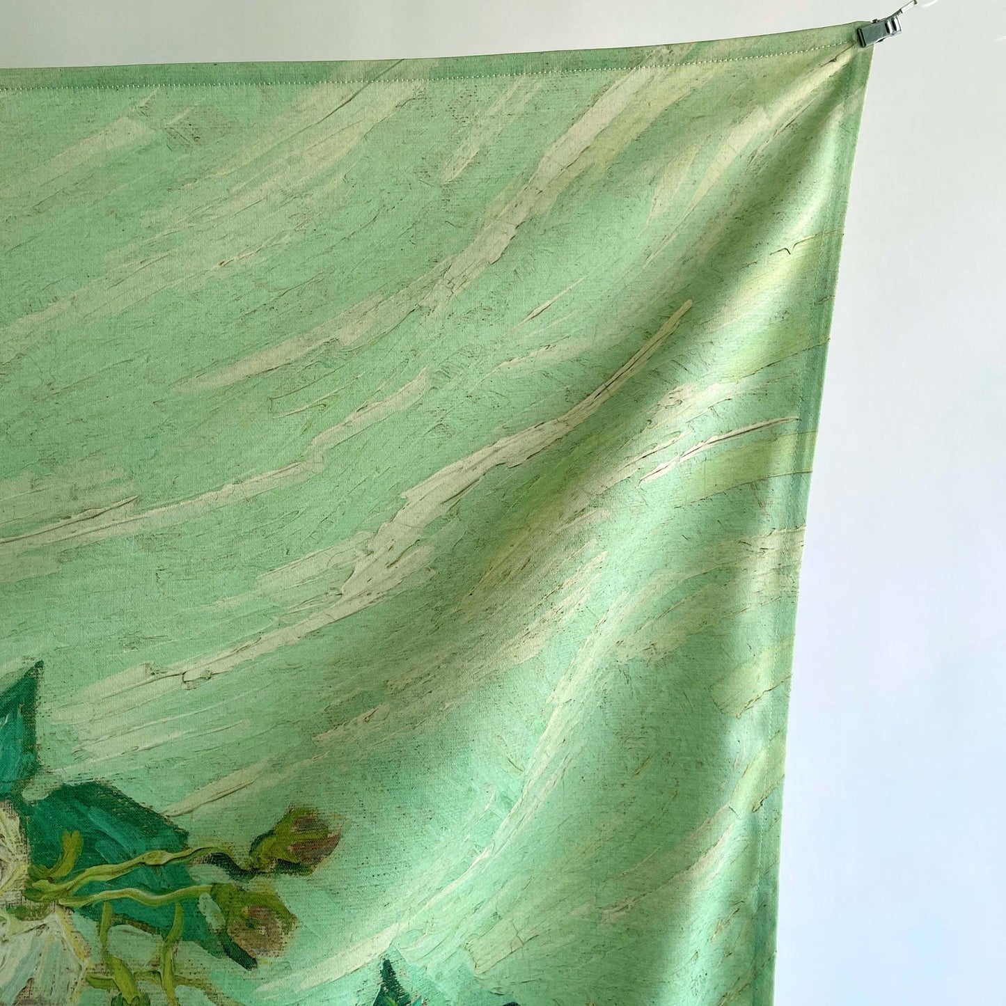 Top corner of tapestry with subtle folds, highlighting the printed texture of the green painted background.