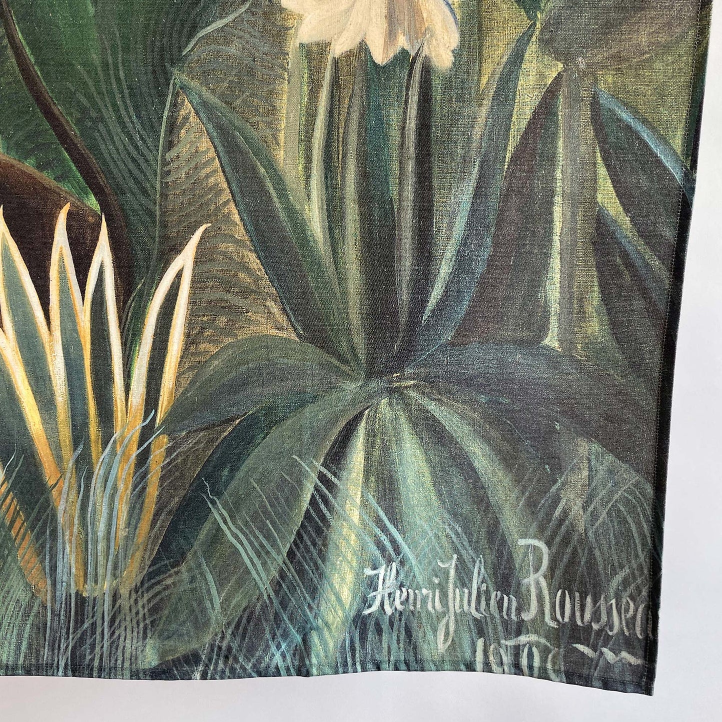 Bottom detail of Rousseau Equatorial Jungle tapestry with visible artist signature and botanical details.