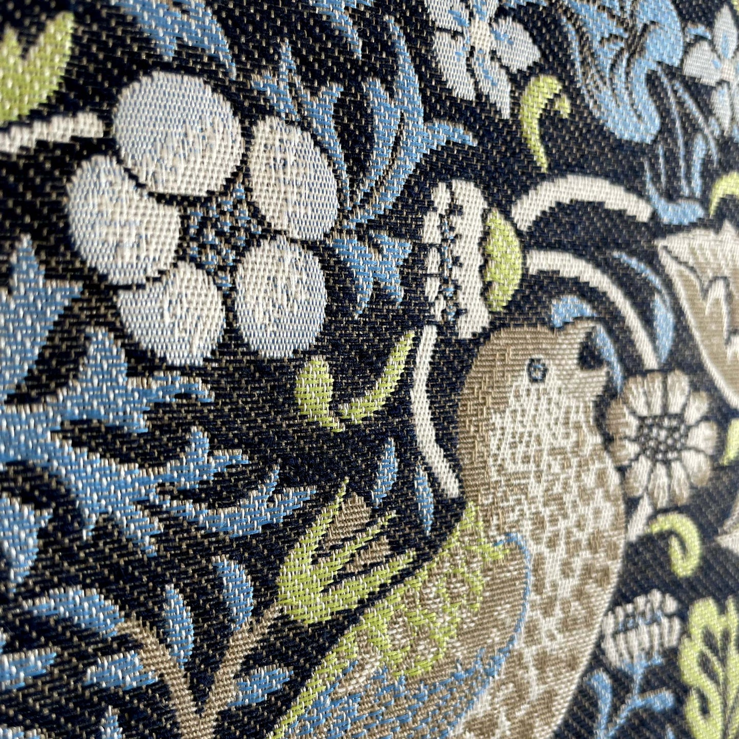 Macro of florals and vines on Strawberry Thief tapestry showing raised weave and crisp pattern definition.