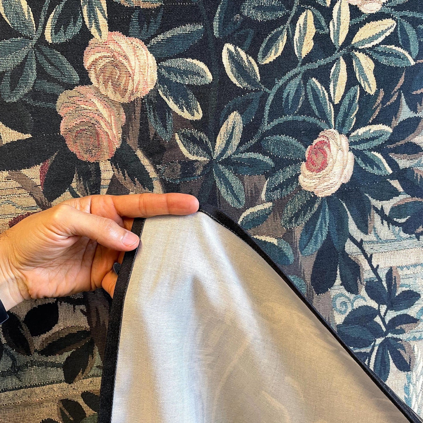 Verdure Chateau Garden wall tapestry fabric and hem—reverse lining and stitched edge with woven foliage and roses.