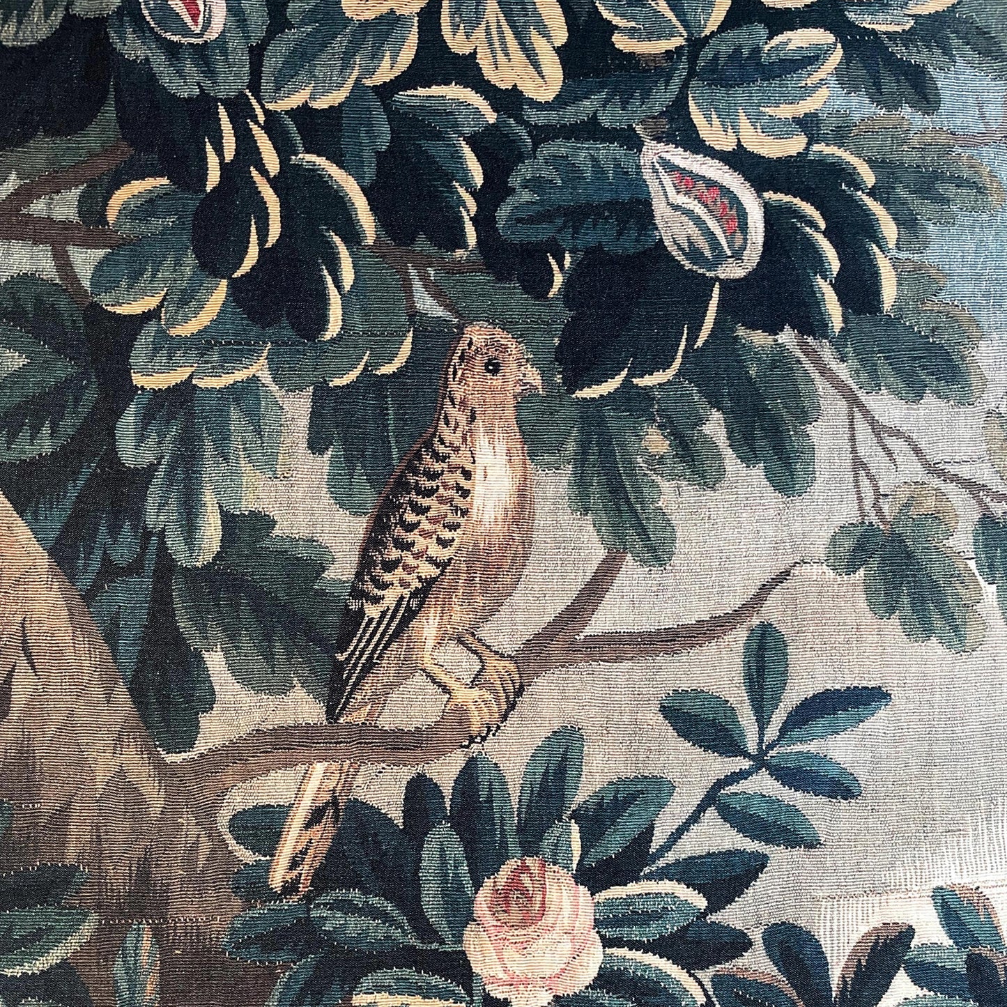 Verdure Chateau Garden tapestry close-up: small brown songbird perched among dark green leaves and pale roses.
