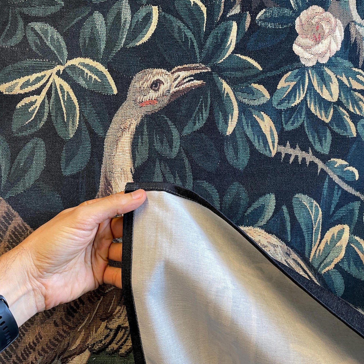 Verdure Chateau Garden tapestry corner—lining and edging revealed beside a crane and rose-strewn foliage.