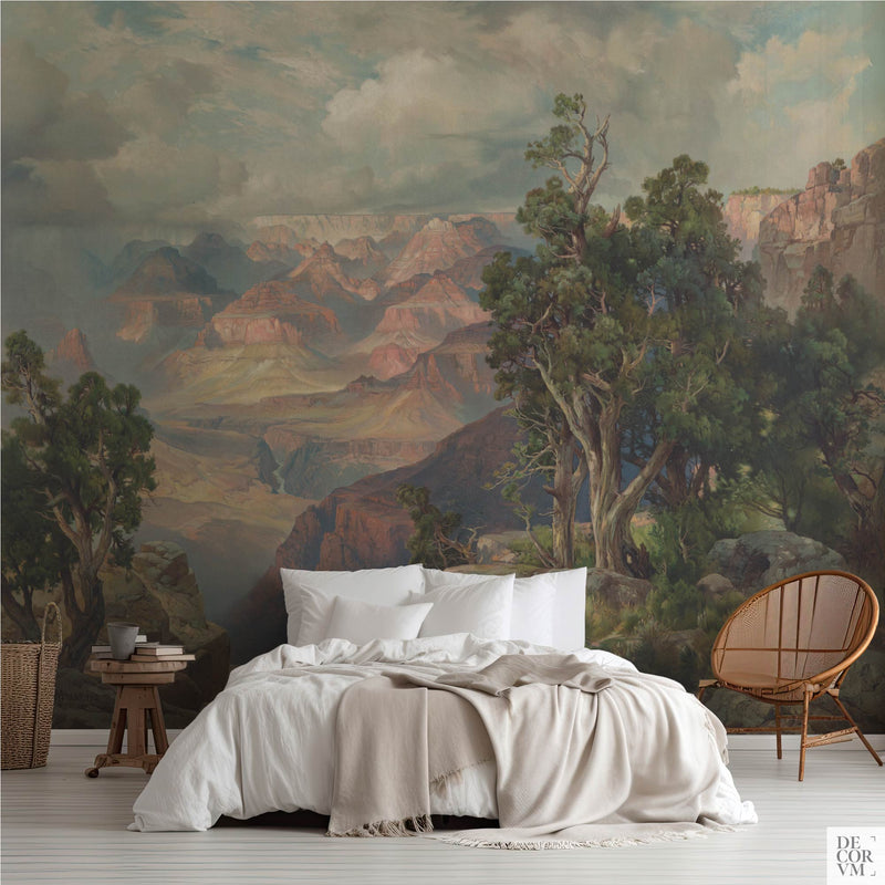 Grand Canyon wallpaper mural by Thomas Moran in a bedroom — panoramic Arizona landscape with canyon ridges and pine trees behind a white bed