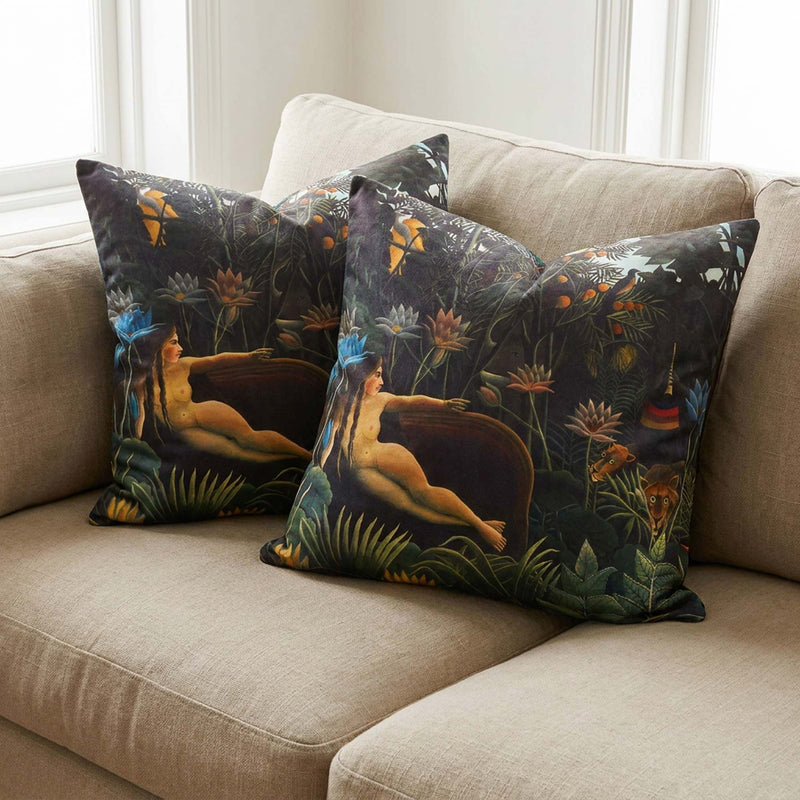 Pair of Henri Rousseau The Dream throw pillows on a beige sofa beside a bright window by Decorvm.