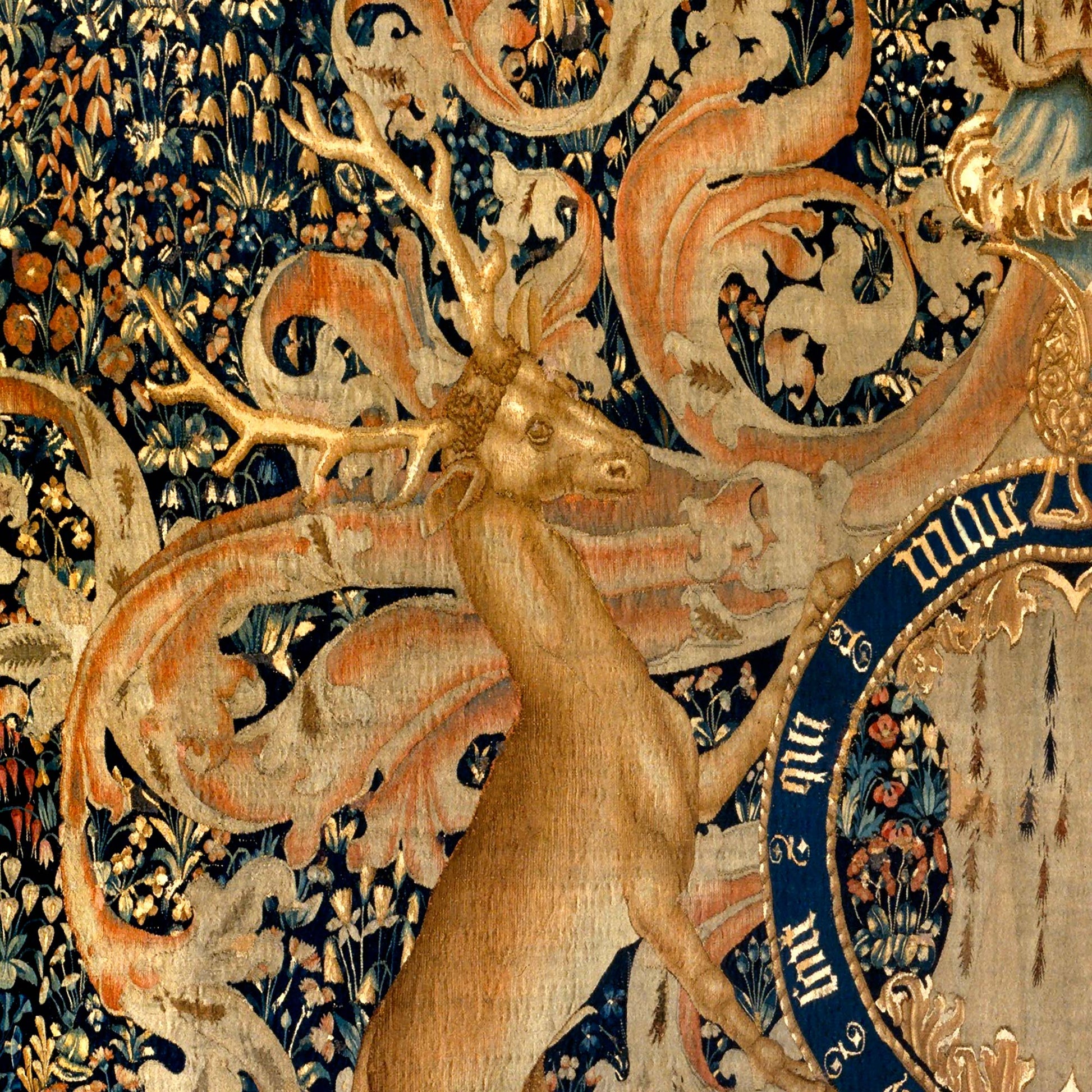 Heraldic deer facing left, richly decorated background with floral motifs and scrollwork.