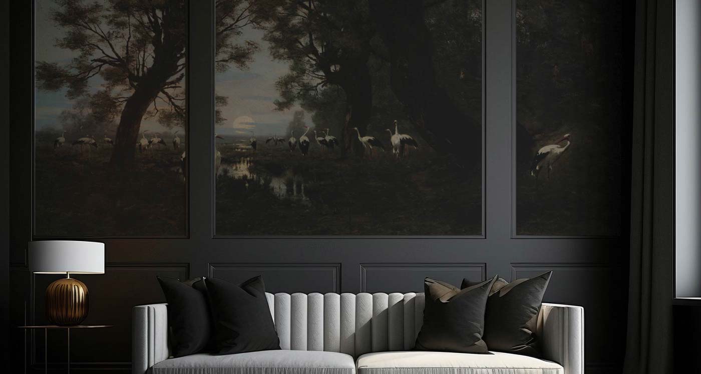 Decorvm website banner showing a dark paneled living room with a white fluted sofa and black pillows. The wall features a large, moody vintage mural of a landscape with storks in a moonlit wetland