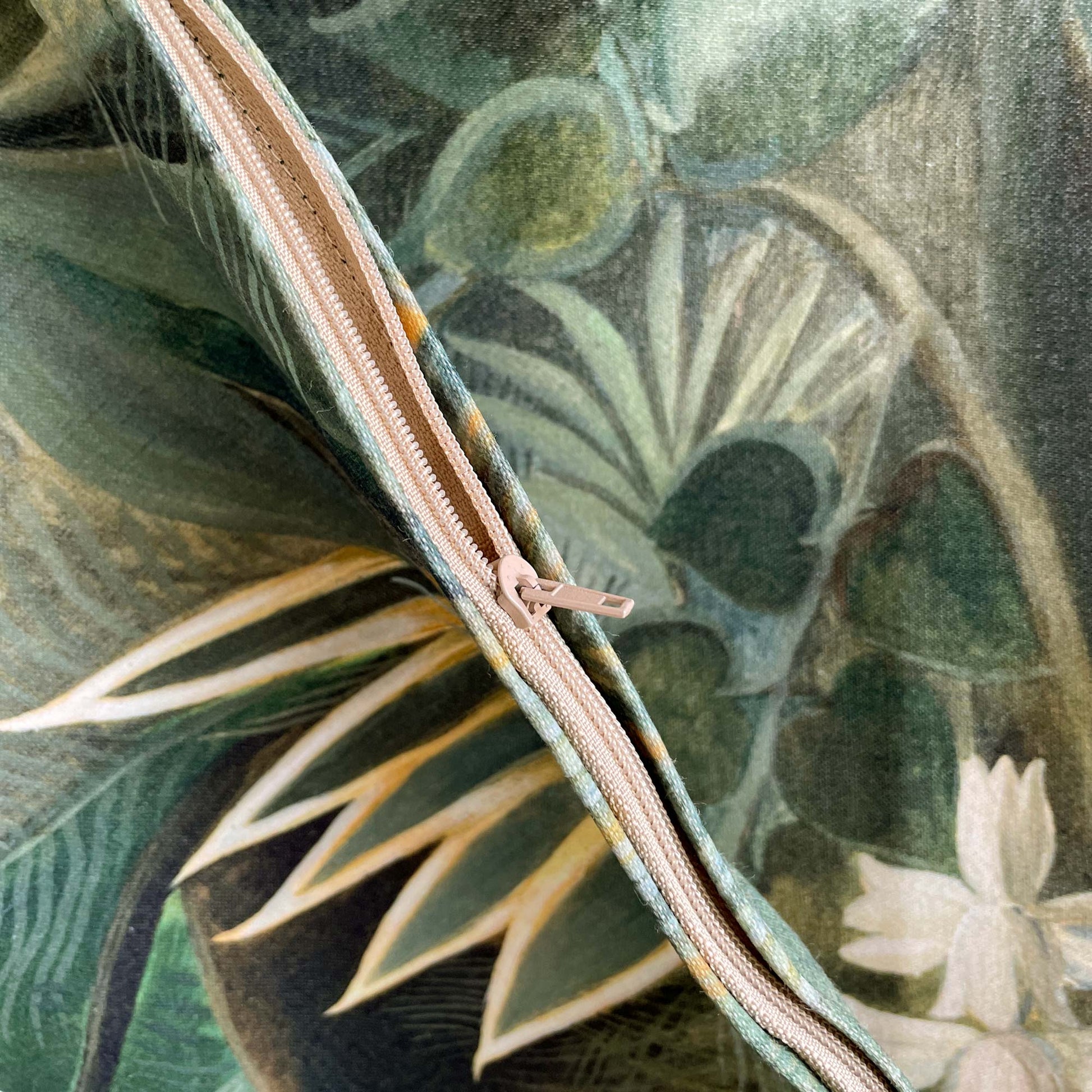 Close-up detail of the concealed zipper on the Henri Rousseau Equatorial Jungle cushion cover, showing premium fabric texture and green botanical print.