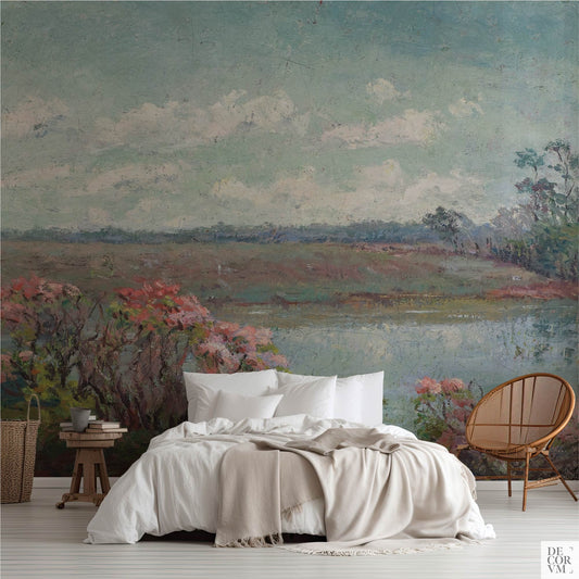Bedroom with impressionist pink-blossom meadow wallpaper mural in soft blues and sage around a reflective water view.