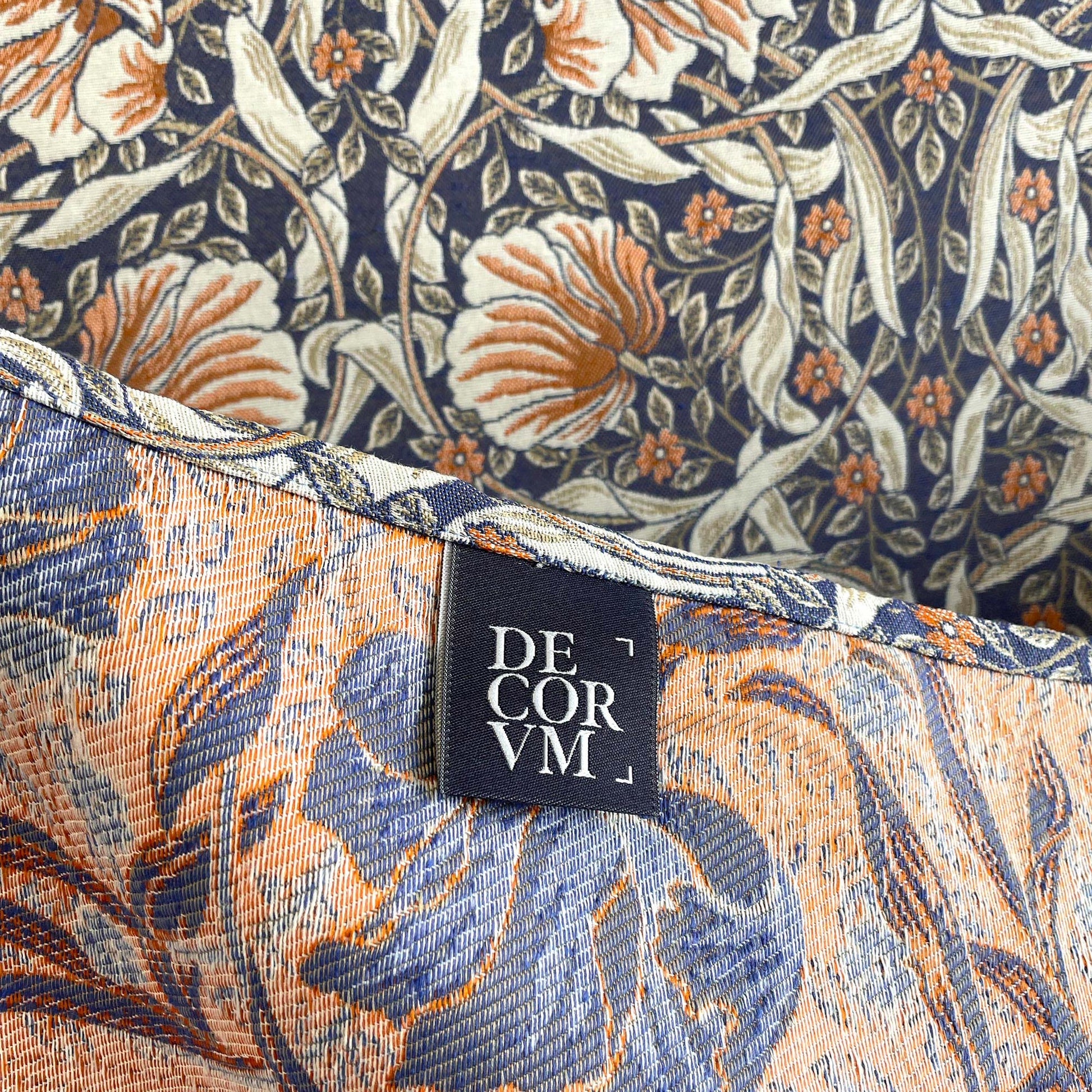 Hem with DECORVM label on the Pimpernel jacquard tapestry, showing two-sided weave and rich colors.