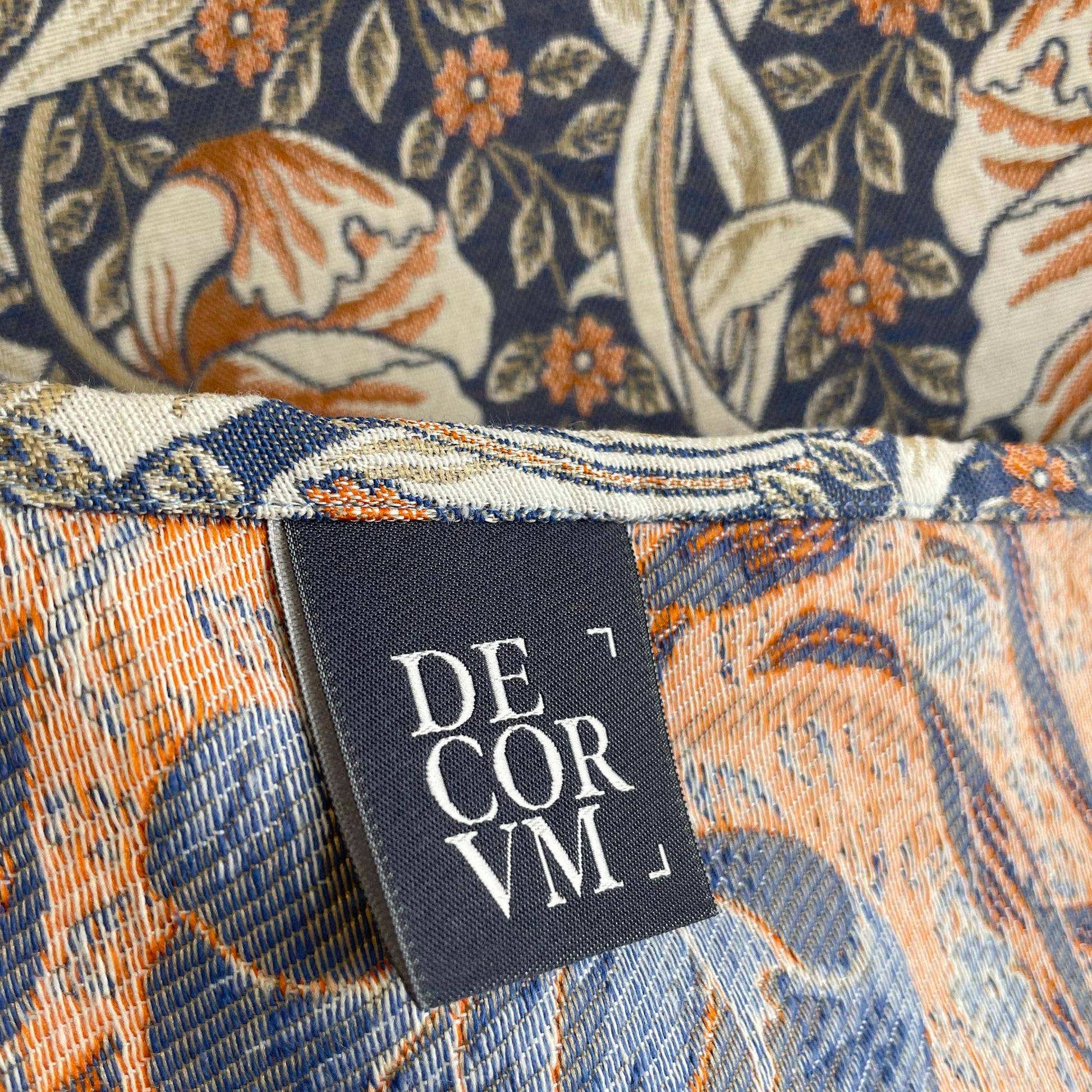DECORVM brand label sewn into the hem of the Pimpernel jacquard with pattern visible on both sides.