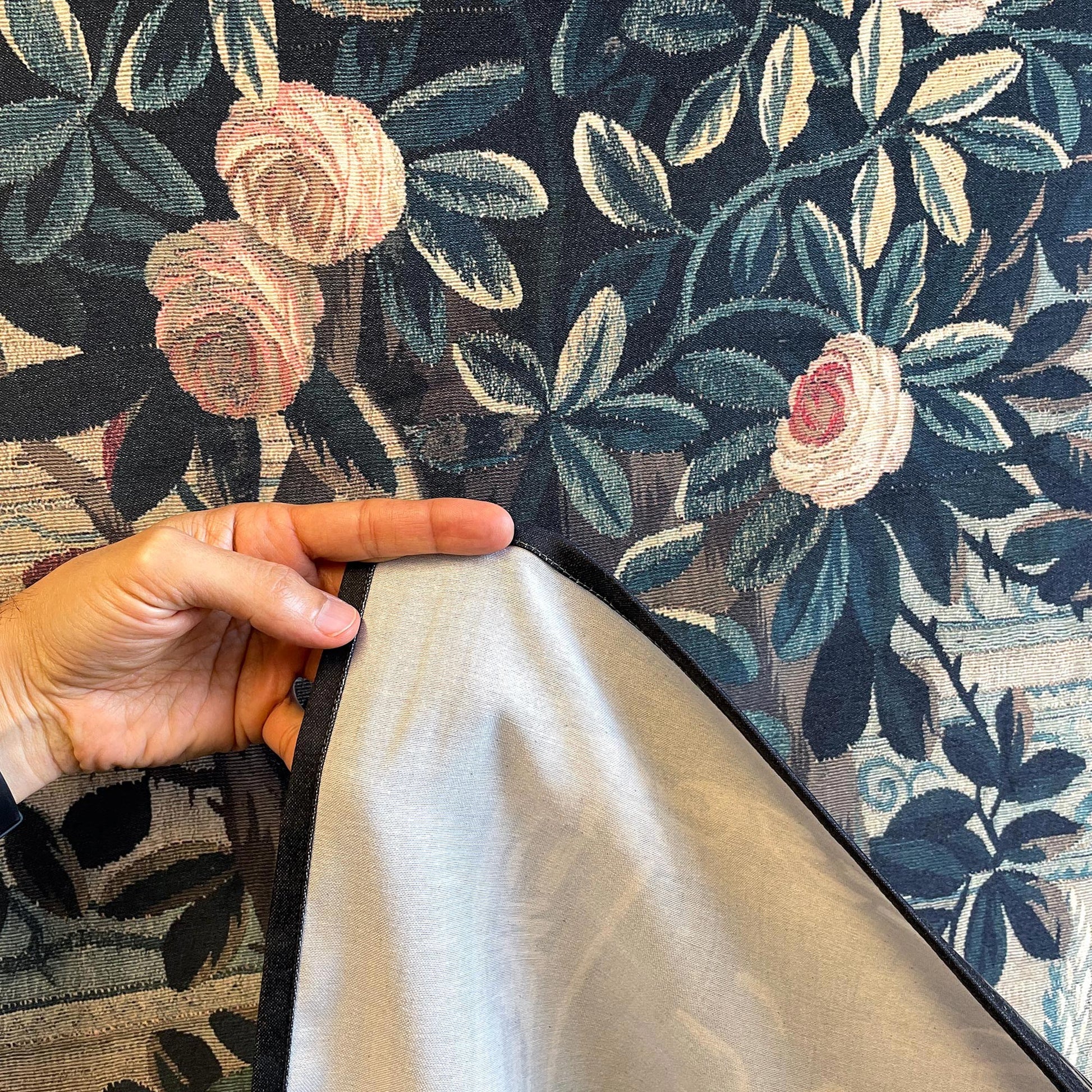Verdure Chateau Garden wall tapestry fabric and hem—reverse lining and stitched edge with woven foliage and roses.