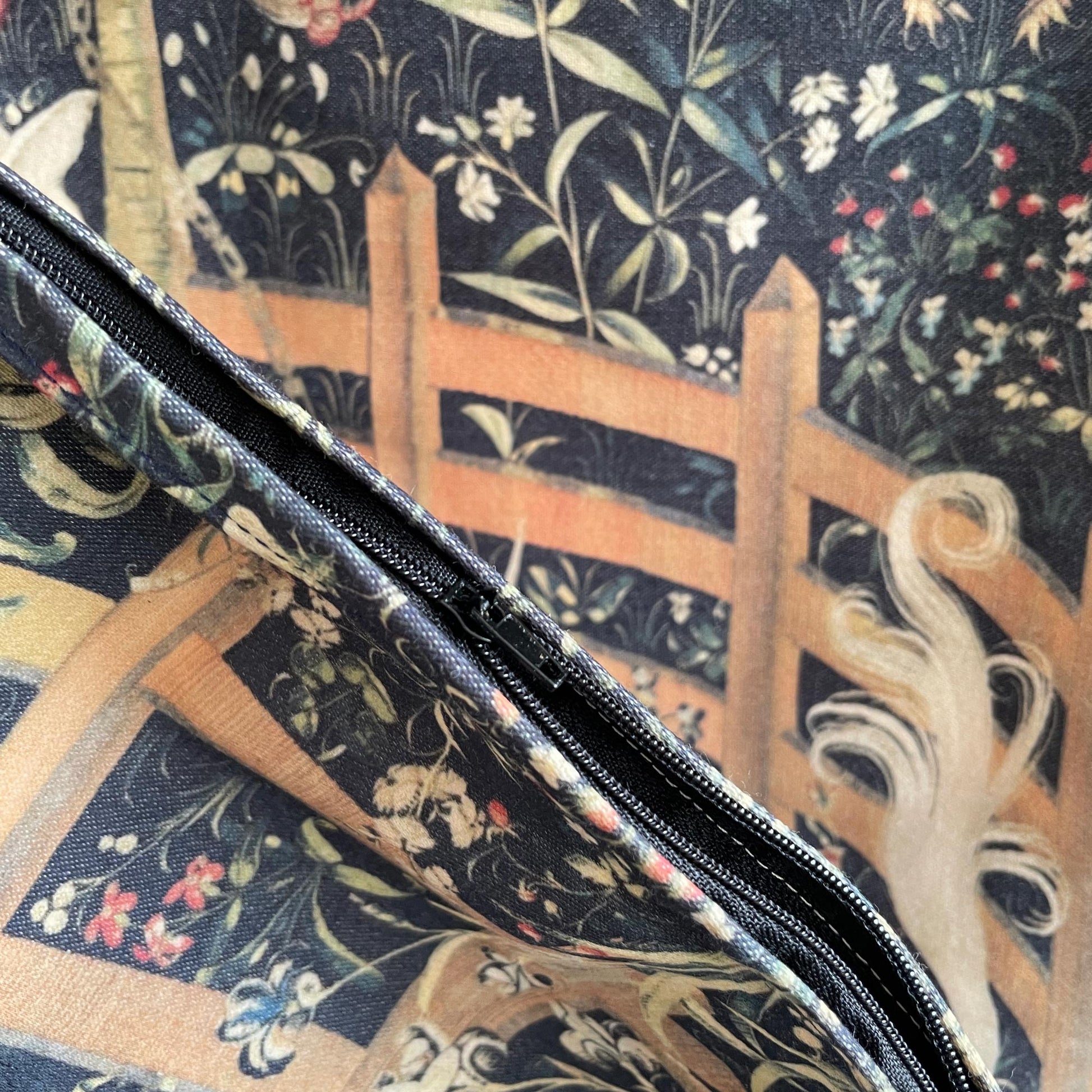 Close-up of the black zipper closure on the Unicorn in Captivity cushion cover, highlighting the seamless finish and durable printed fabric.