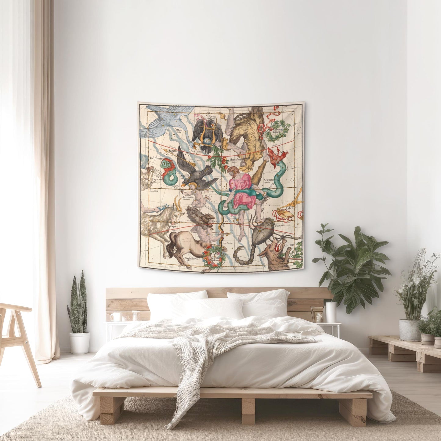 Hercules and Sagittarius celestial map tapestry hung above a wooden platform bed with white linens and indoor plants.