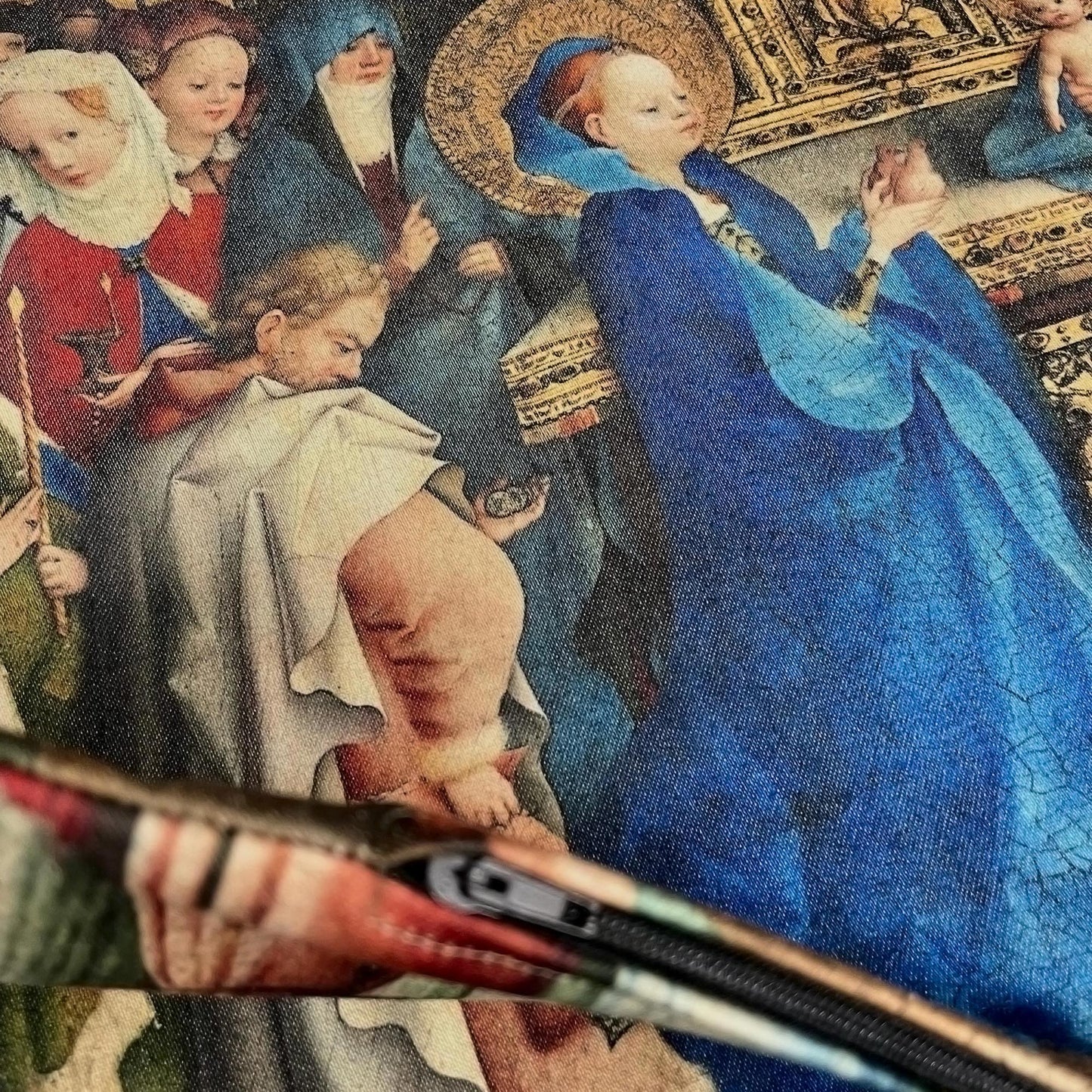 Edge and closed zipper detail of the medieval Virgin Mary cushion cover against the printed Gothic artwork.