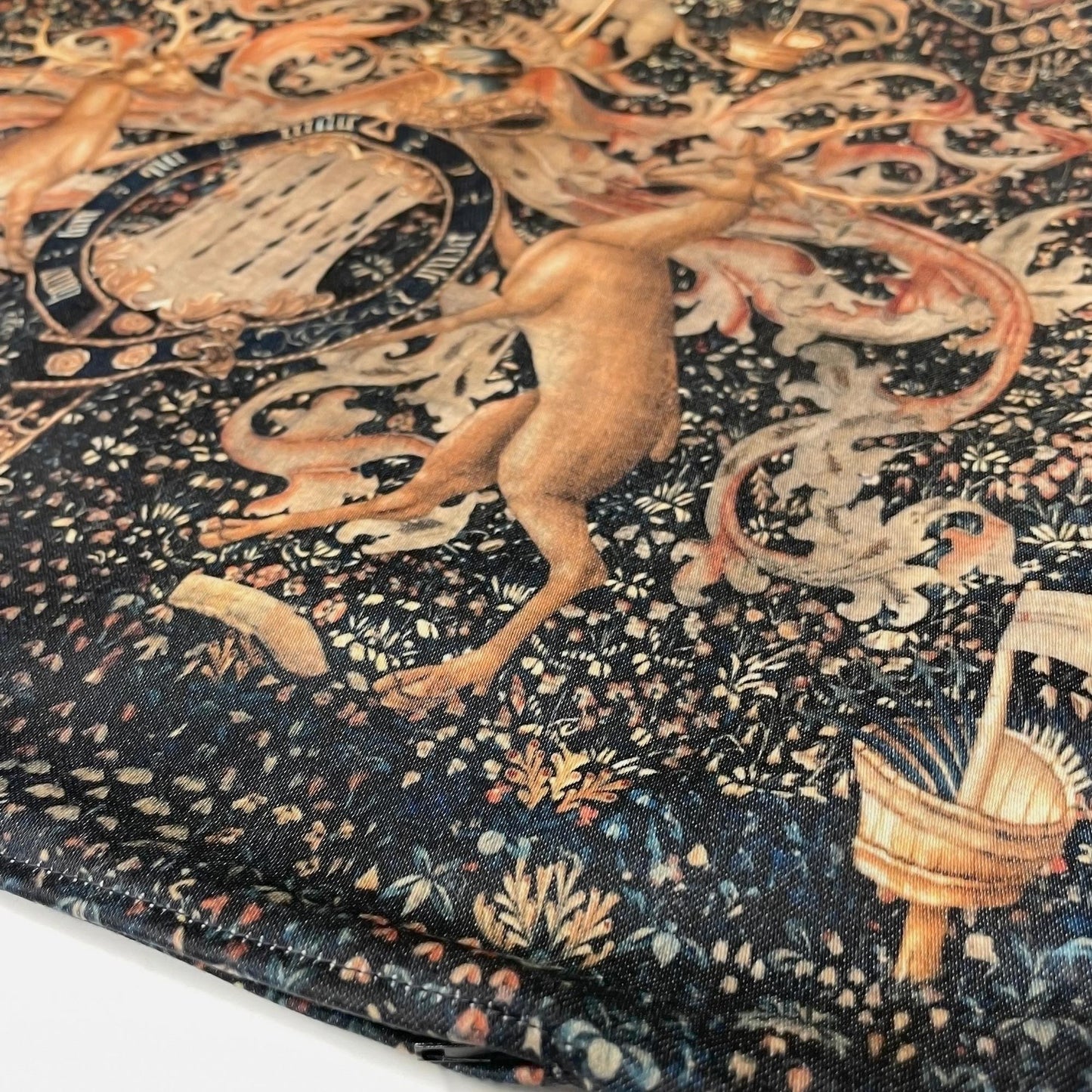 Close-up of the bottom seam on the Medieval Heraldry cushion cover, showing the heraldic stag motif and dark floral print.