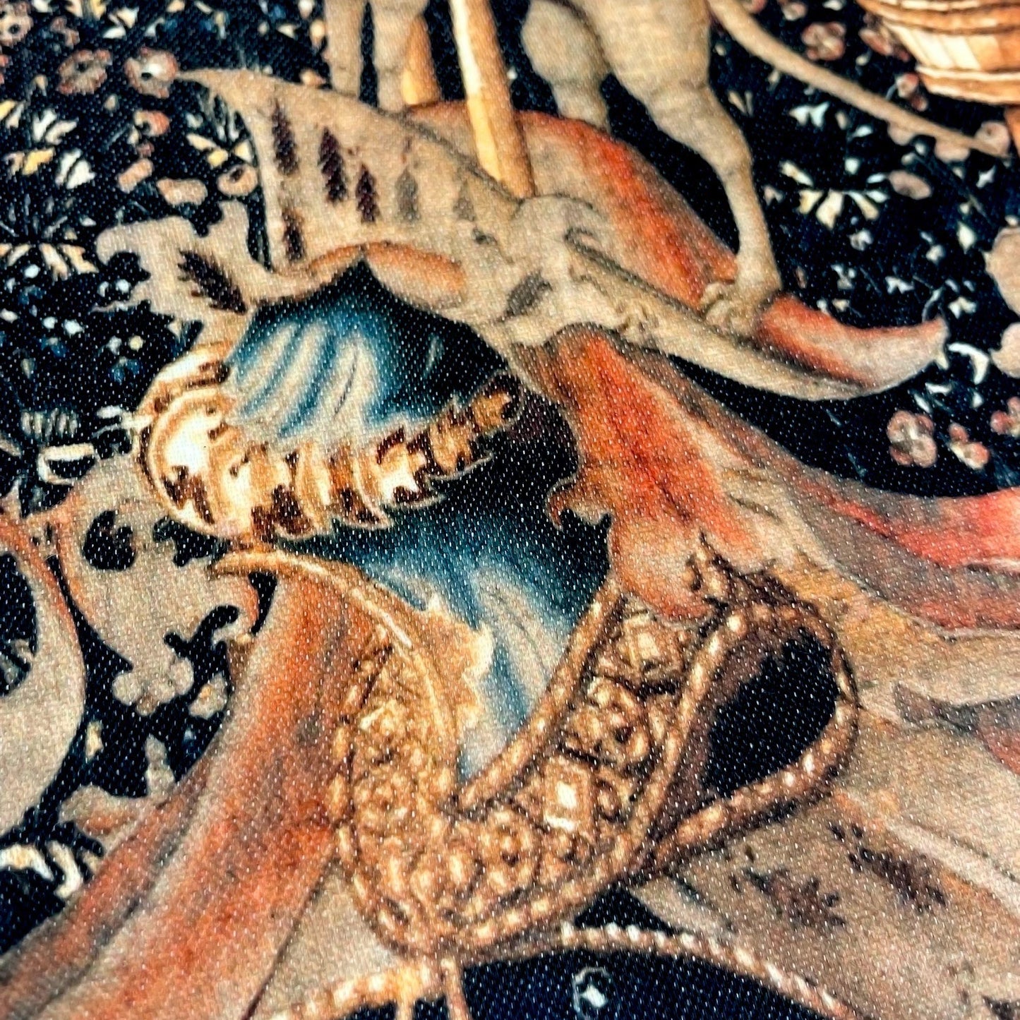 Close-up of the ornate knight's helmet and intricate swirling mantling — design detail from the late 15th-century Lord Dynham tapestry.