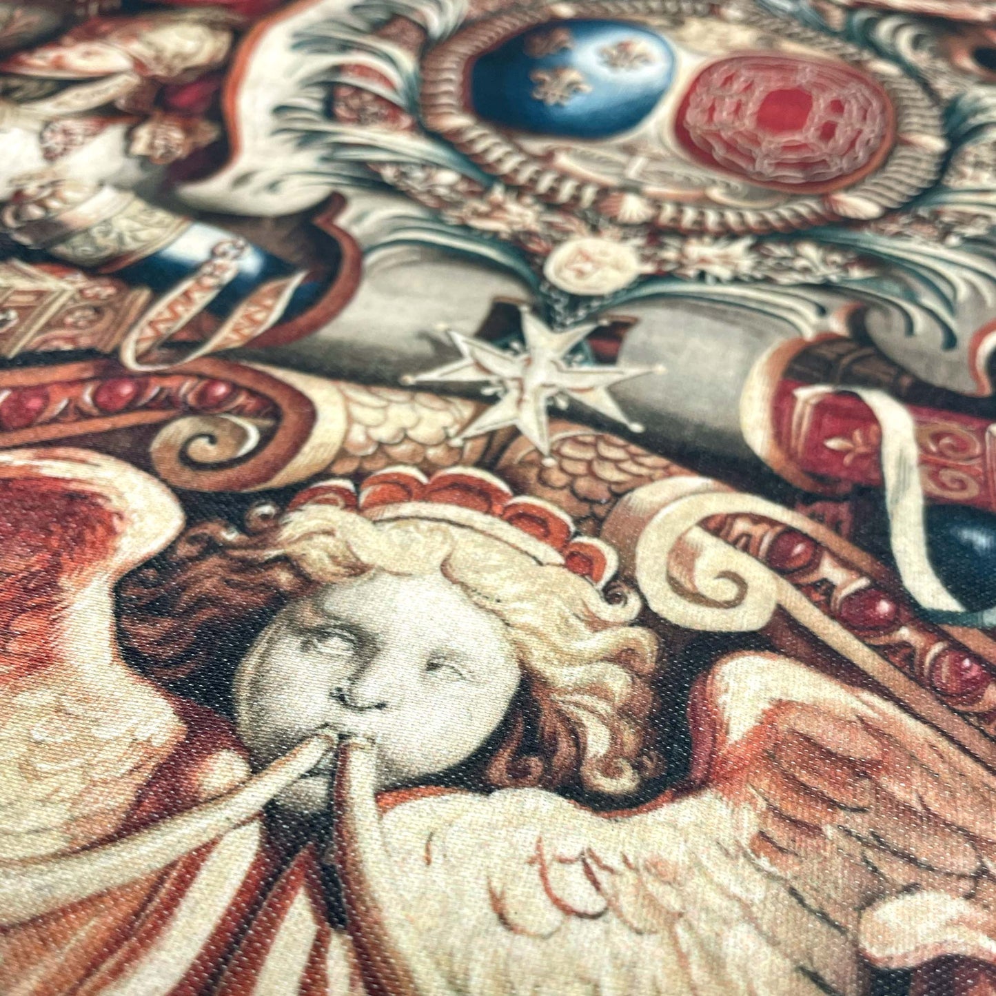 Close-up of an angelic cherub and intricate red and gold detailing — design detail from Charles Le Brun's Portière of the Chariot of Triumph.
