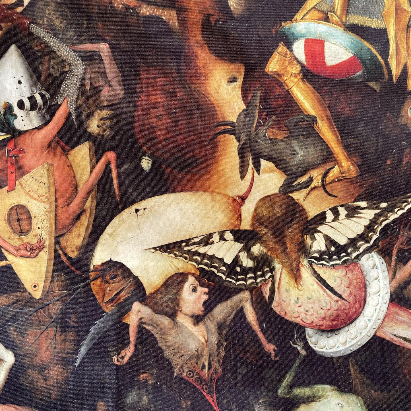 Close-up of grotesque figures, a butterfly-winged creature, and a cracked egg-shaped shell — design detail from Bruegel's Fall of the Rebel Angels.