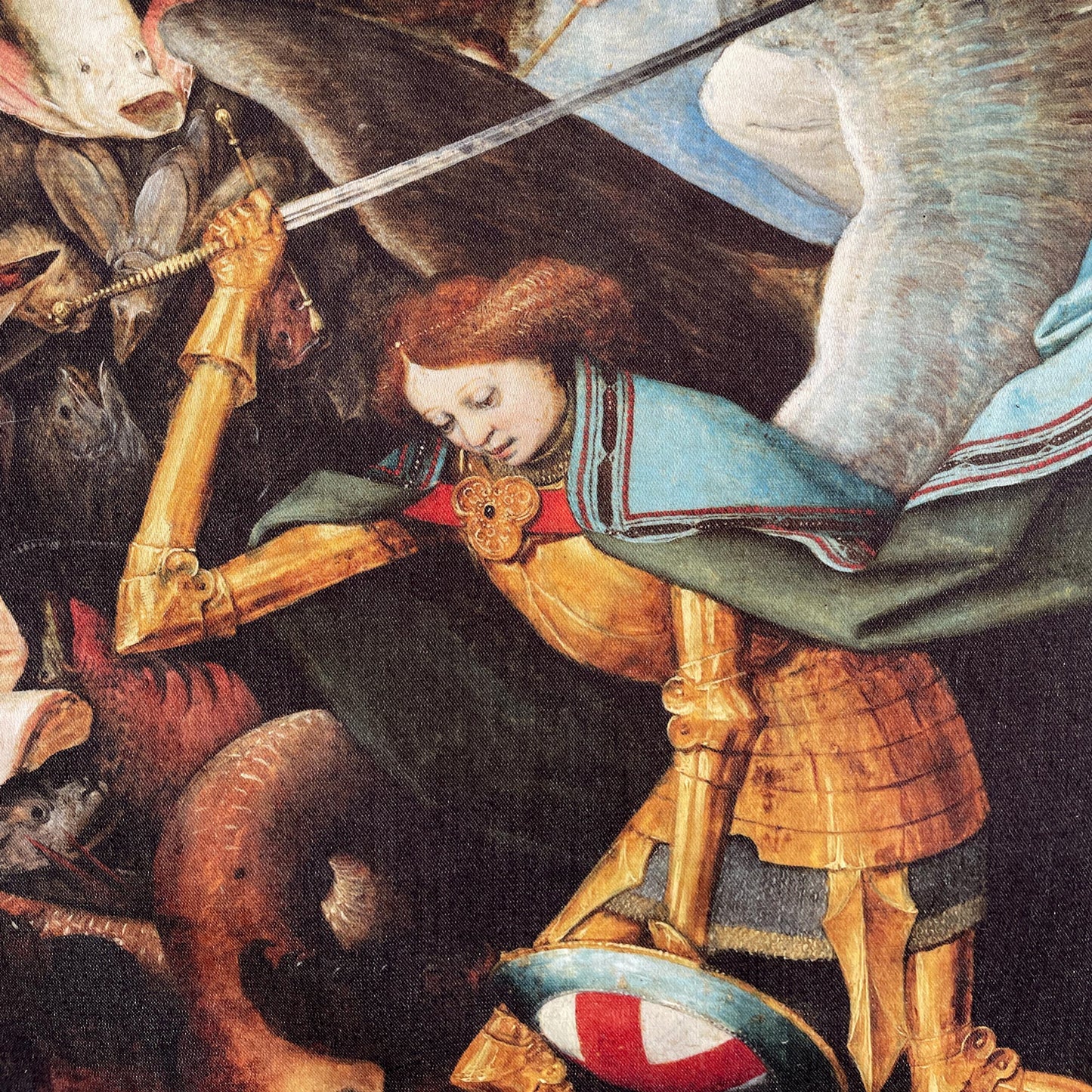 Close-up of St Michael in golden armor fighting the multi-headed dragon — design detail from Bruegel's Fall of the Rebel Angels.