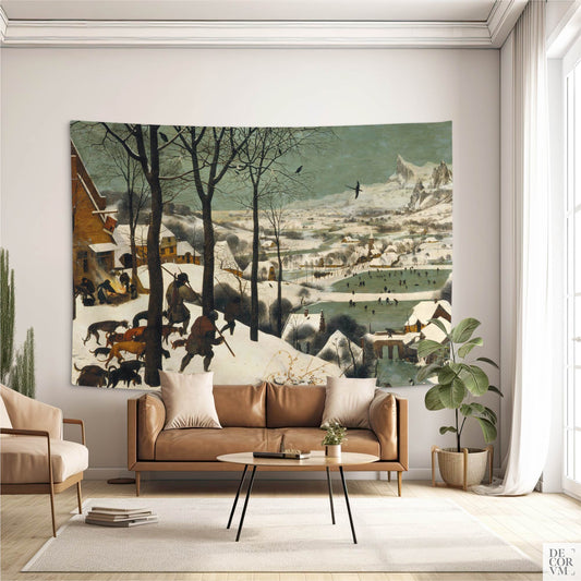 "Hunters in the Snow" wall tapestry over tan leather sofa; Bruegel winter landscape adds old-world warmth to a neutral living room.