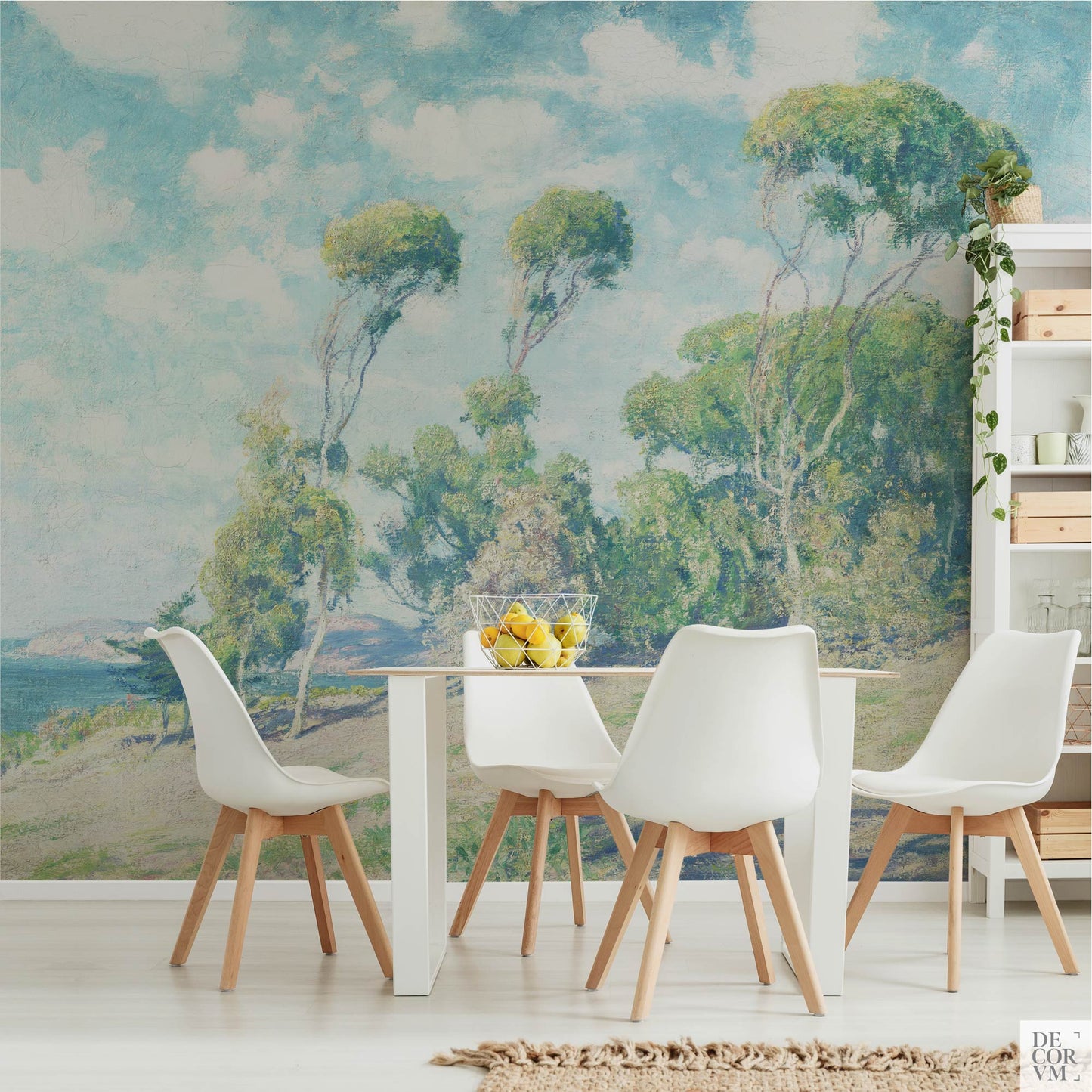 Eucalyptus coastal wallpaper mural in a light dining room — vintage California impressionist scene behind a modern white dining table with warm wood accents