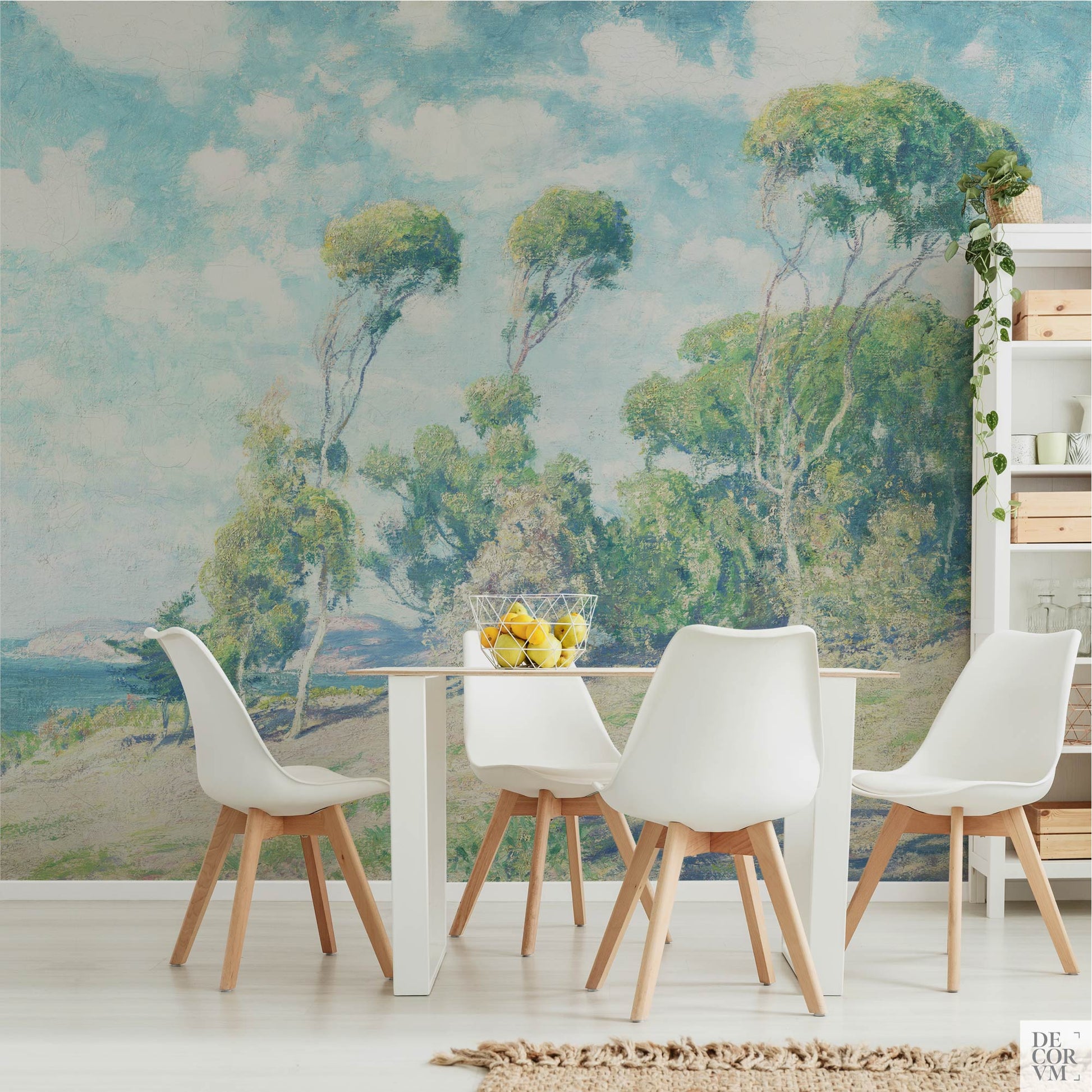 Eucalyptus coastal wallpaper mural in a light dining room — vintage California impressionist scene behind a modern white dining table with warm wood accents