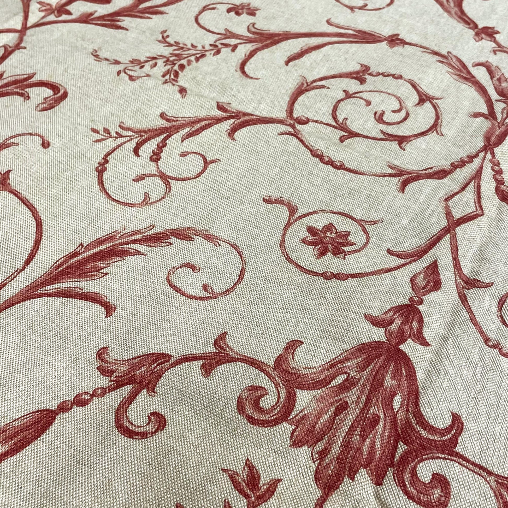Burgundy red floral centerpiece flanked by delicate vines and acanthus leaves printed on a textured beige fabric.
