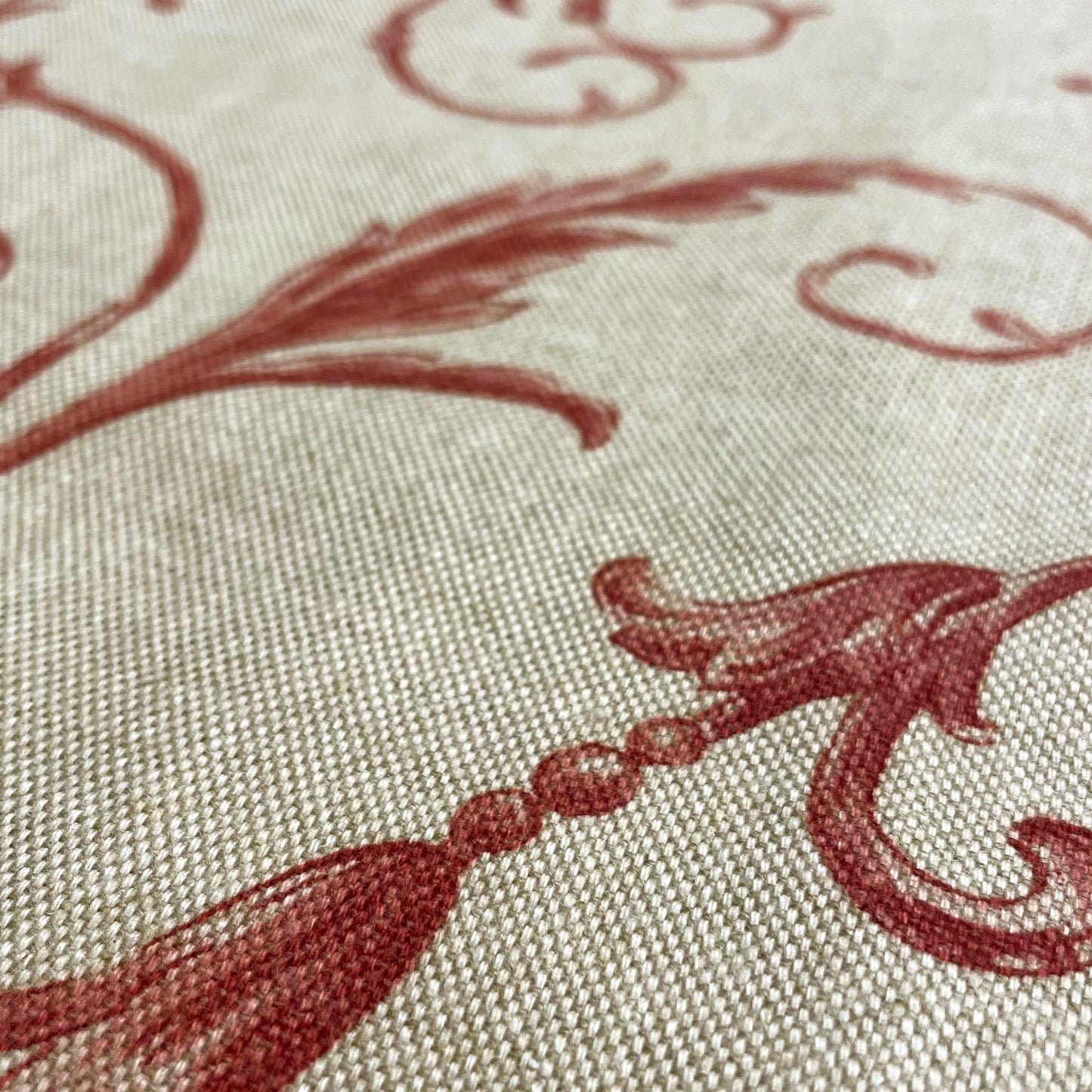 Intricate extreme close-up of the fabric texture highlighting a printed design element resembling a beaded crimson tassel attached to a traditional sweeping leaf.