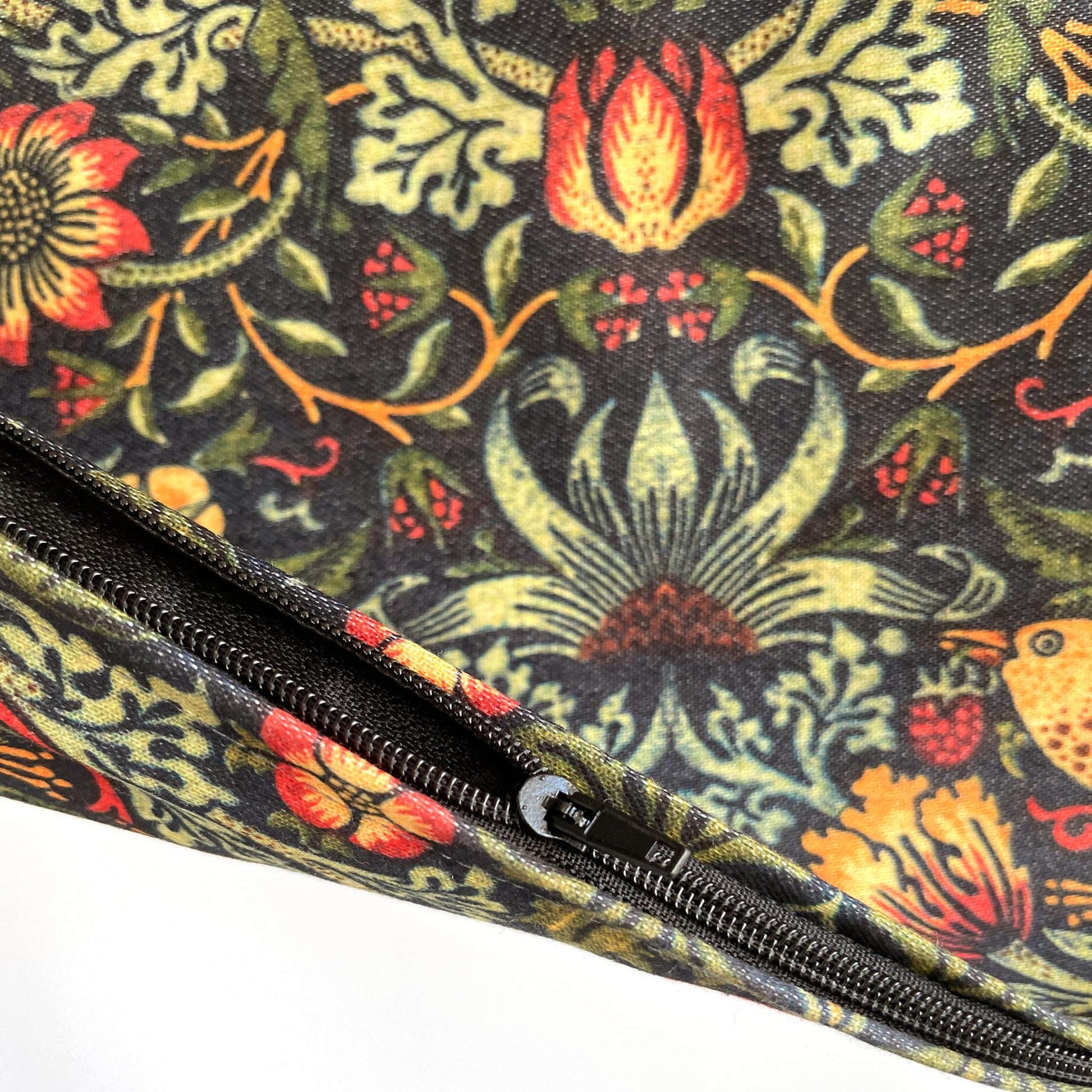 Corner zipper detail on the William Morris Strawberry Thief pillow cover in dark green.