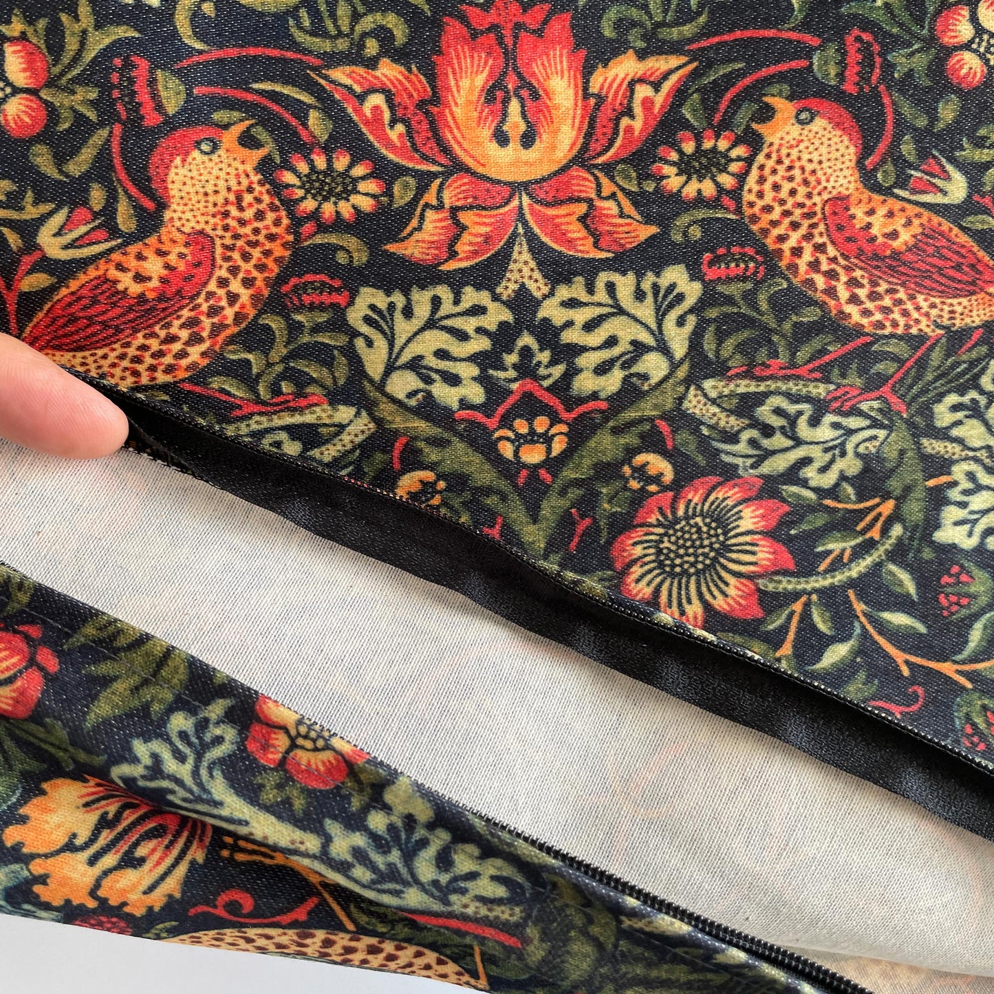 Interior construction of the Strawberry Thief pillow cover showing white lining and black zipper.