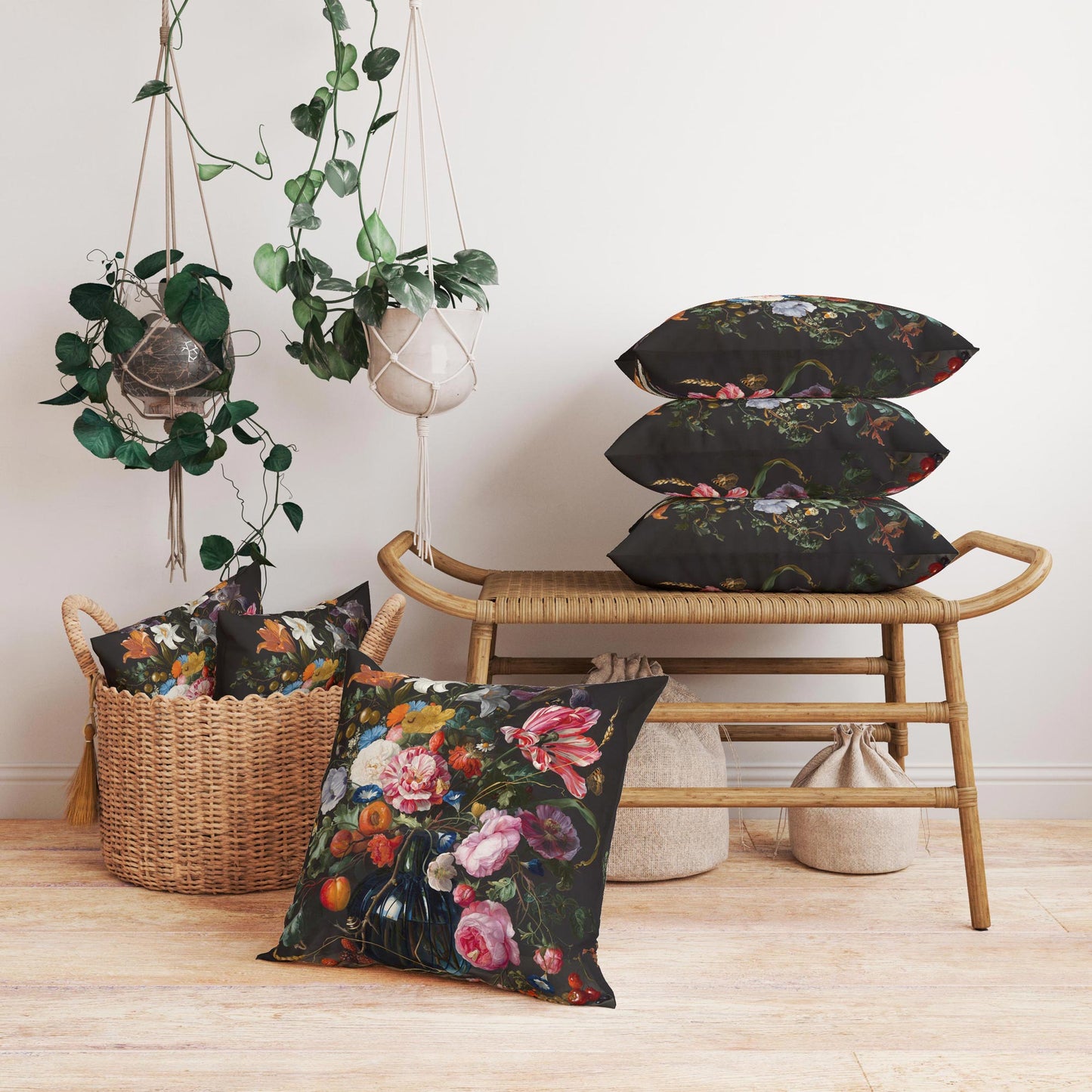 Maximalist decor vignette featuring Dutch Floral cushion covers stacked on a woven rattan bench and displayed in a rustic basket with hanging plants.
