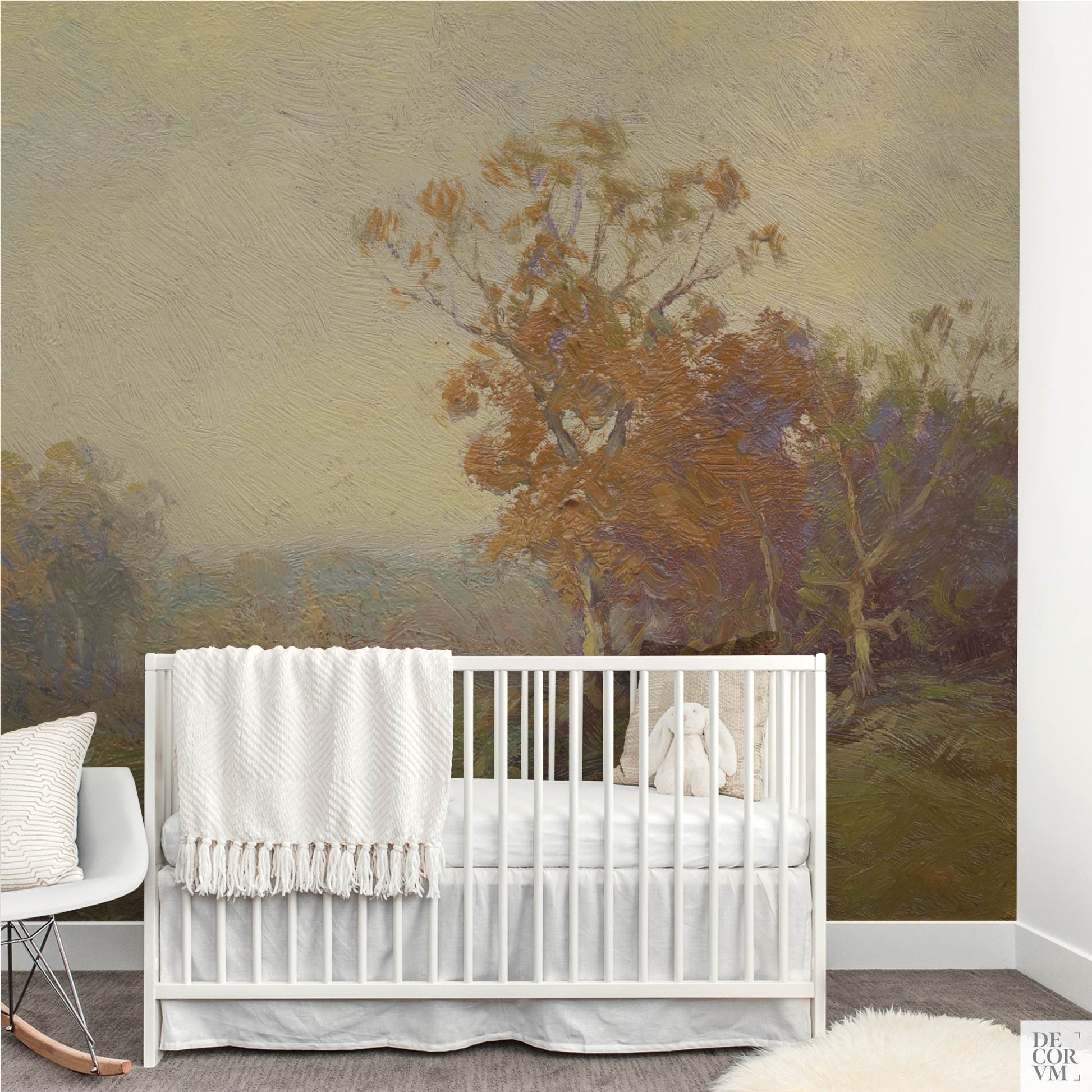 Golden autumn landscape wallpaper mural in a nursery with white crib, stuffed bunny, and rocking chair
