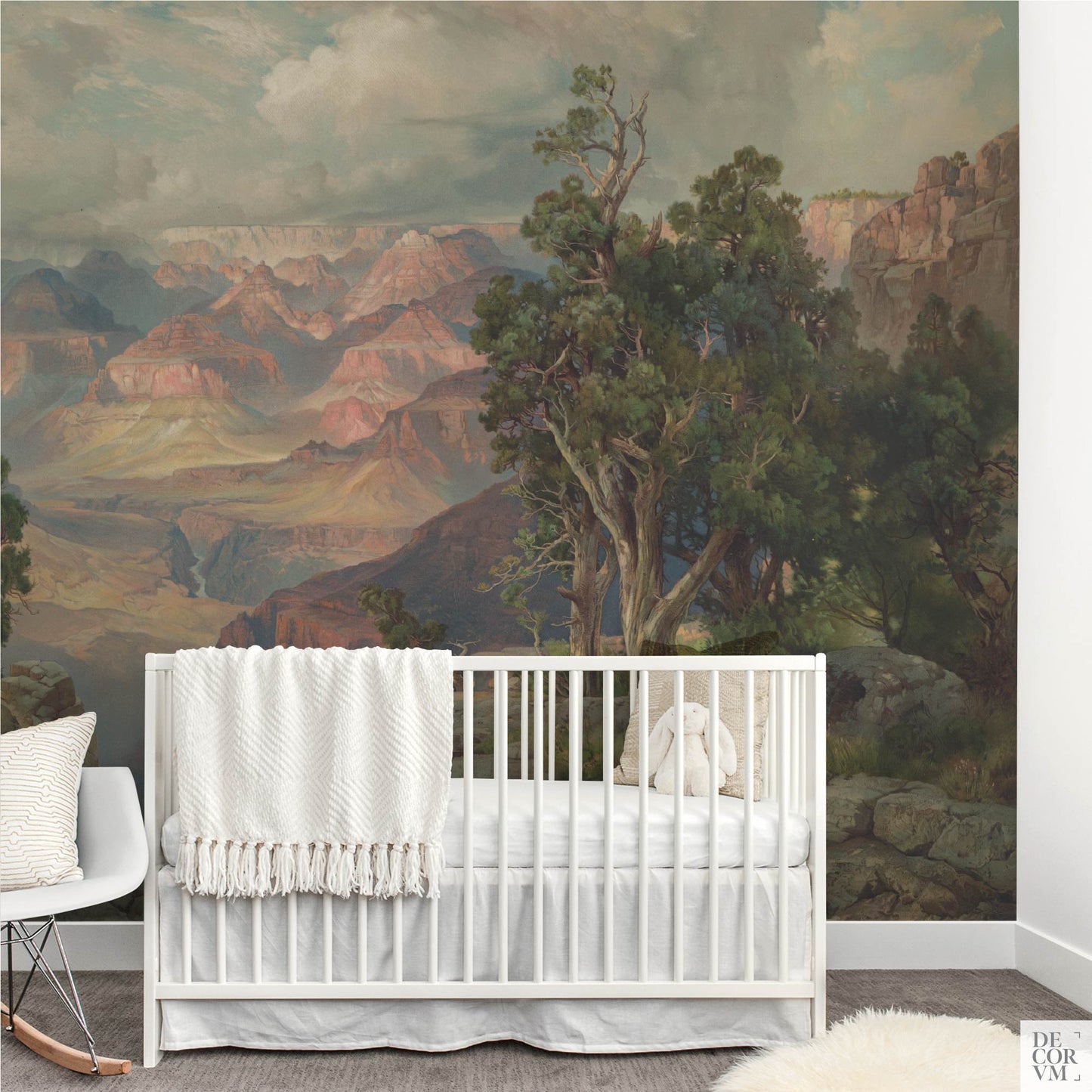 Historic Americana Grand Canyon scenery used as a calming, earthy wallpaper mural behind a white crib in a transitional nursery room.