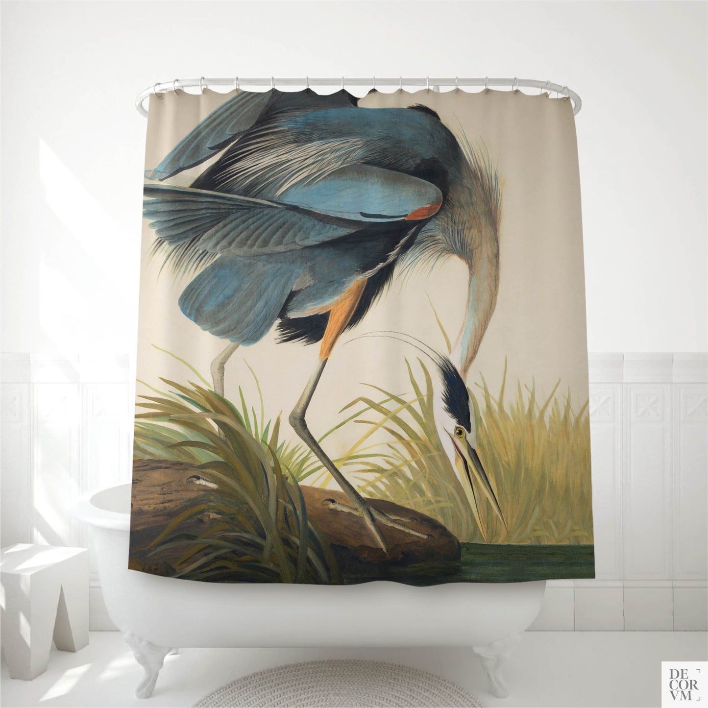 Great Blue Heron shower curtain hanging over a white clawfoot bathtub in a bright bathroom — Audubon's iconic slate-blue heron poised over marsh grasses at the water's edge, by Decorvm.