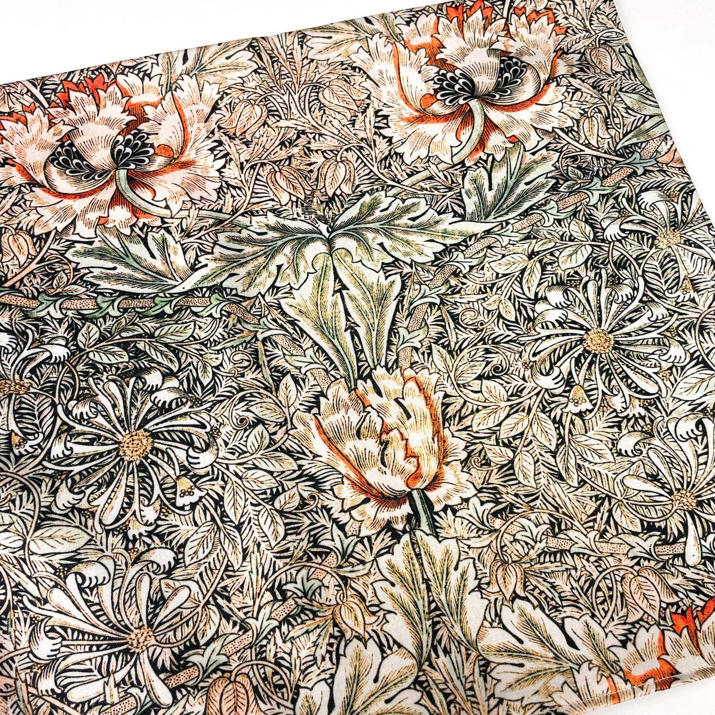 Flat lay of the May Morris Honeysuckle pillow cover showing the dense orange and cream floral repeat.