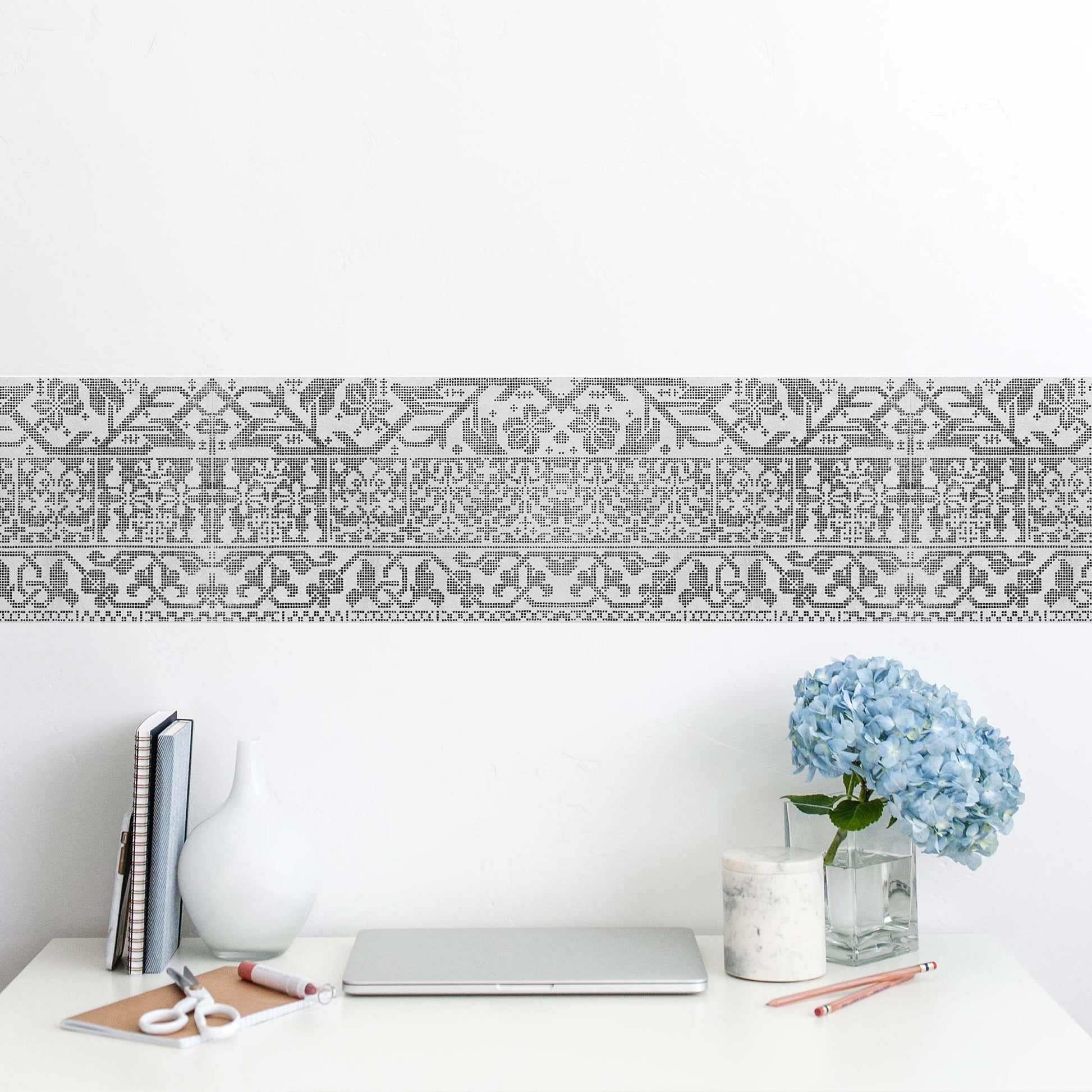 Italian lacework peel and stick wall border in light gray — bright home office workspace above a sleek white desk with blue hydrangeas