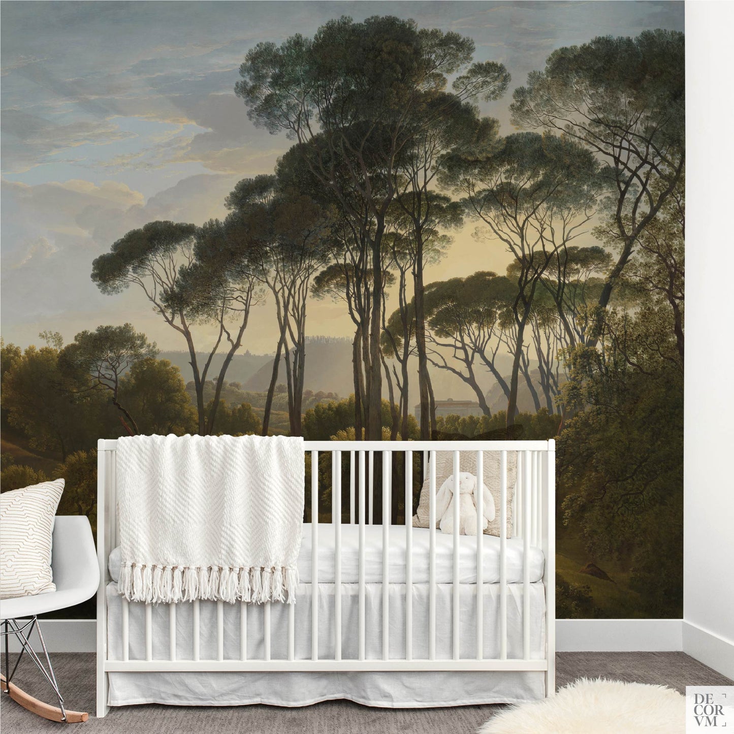 Italian umbrella pines landscape wallpaper mural in a nursery with white crib, knitted blanket, and stuffed toy.