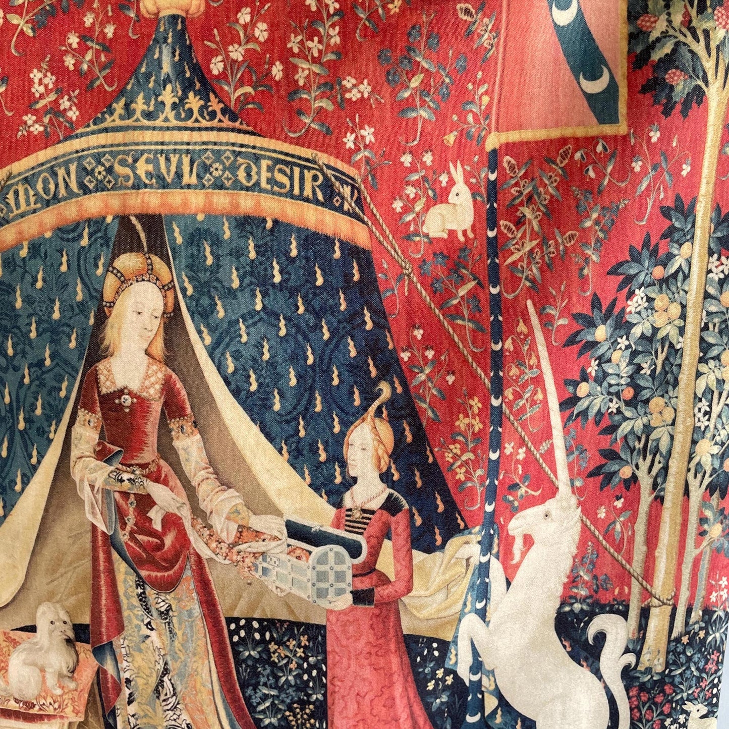 Detailed central view of the Lady and the Unicorn tapestry — medieval noblewoman with maidservant in front of a blue tent inscribed 'À Mon Seul Désir,' flanked by a small dog and a white unicorn.