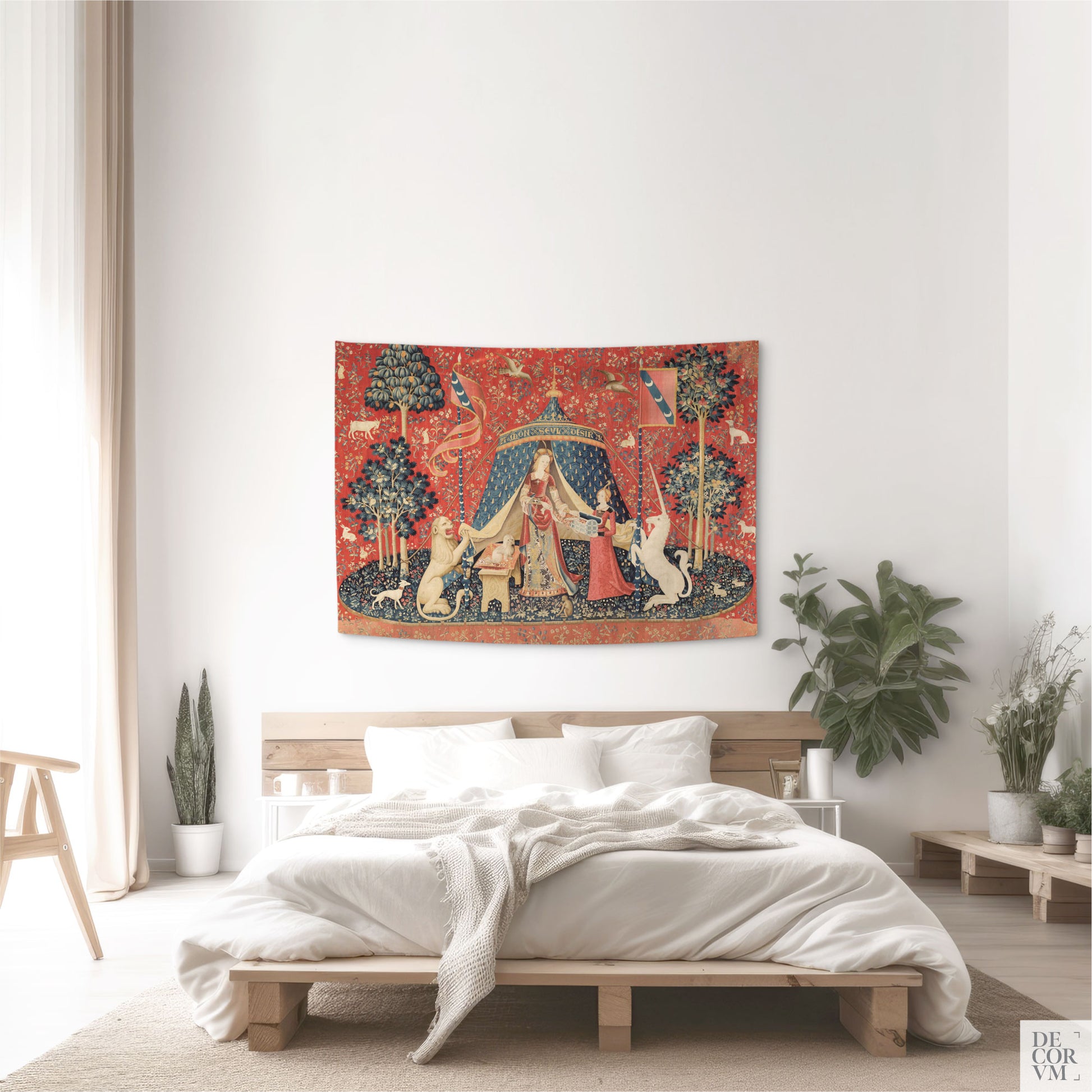 Small Lady and the Unicorn wall tapestry above a minimalist wooden platform bed in a bright, airy bedroom.