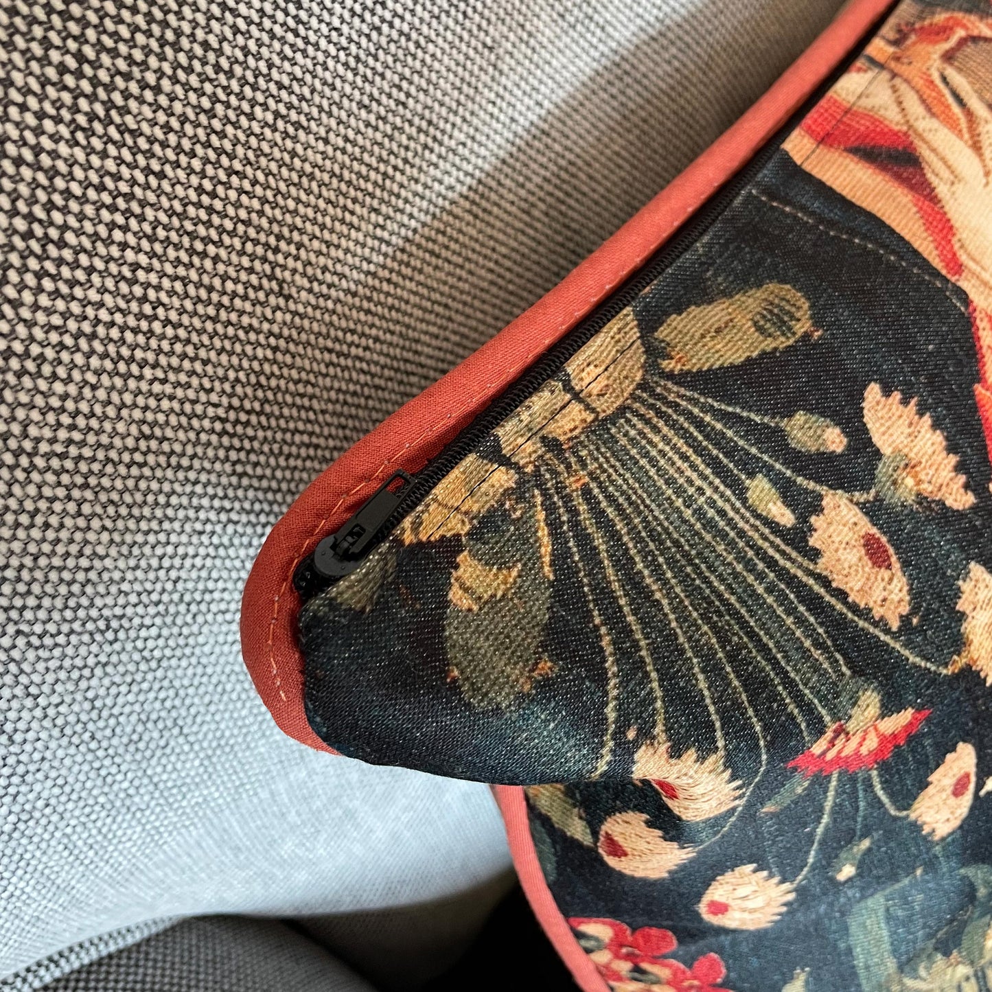 Detail of the discreet hidden zipper closure next to the elegant red corded piping on the Medieval Amazon Queen cushion cover.