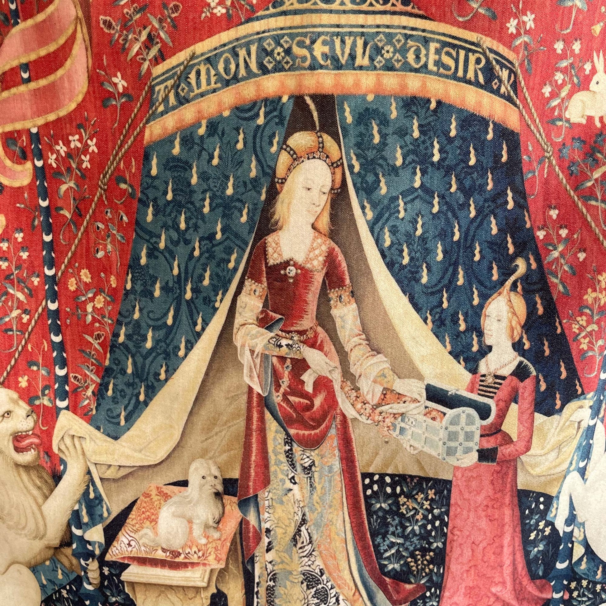 Close-up detail of the "À mon seul désir" cushion cover — elegant noblewoman, her maidservant, small dog, and intricate blue tent against the crimson millefleur background.