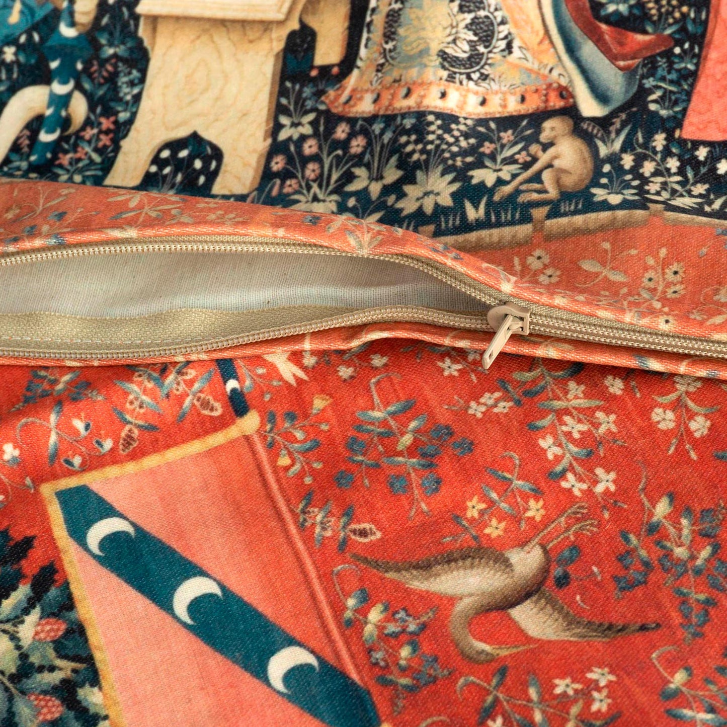 Open zipper detail of the Lady and the Unicorn medieval cushion cover, revealing the clean inner edge and the woven texture of red millefleur and bird motif.
