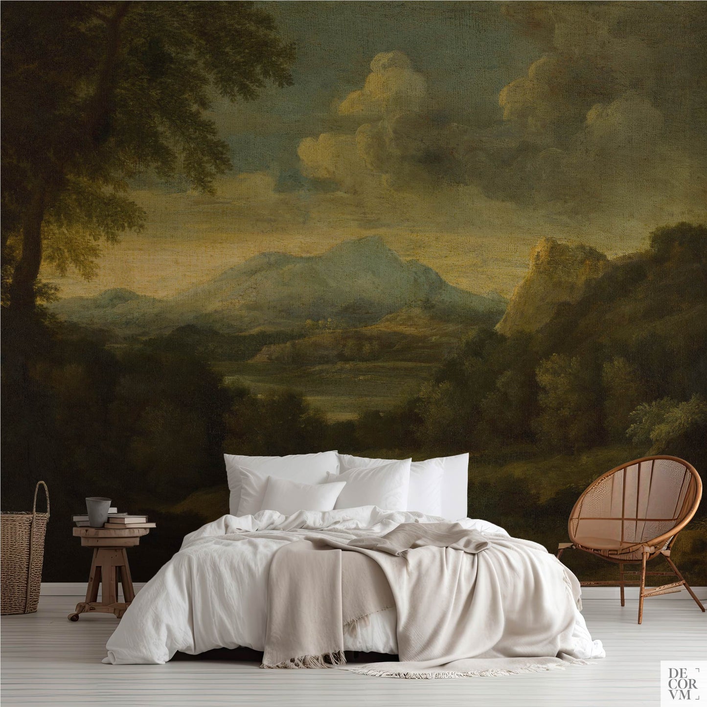 A bedroom scene featuring the Moody Mountain Landscape Wallpaper Mural — Dark Academia Decor behind a bed with white linens, a wooden stool, and a rattan chair on the right.