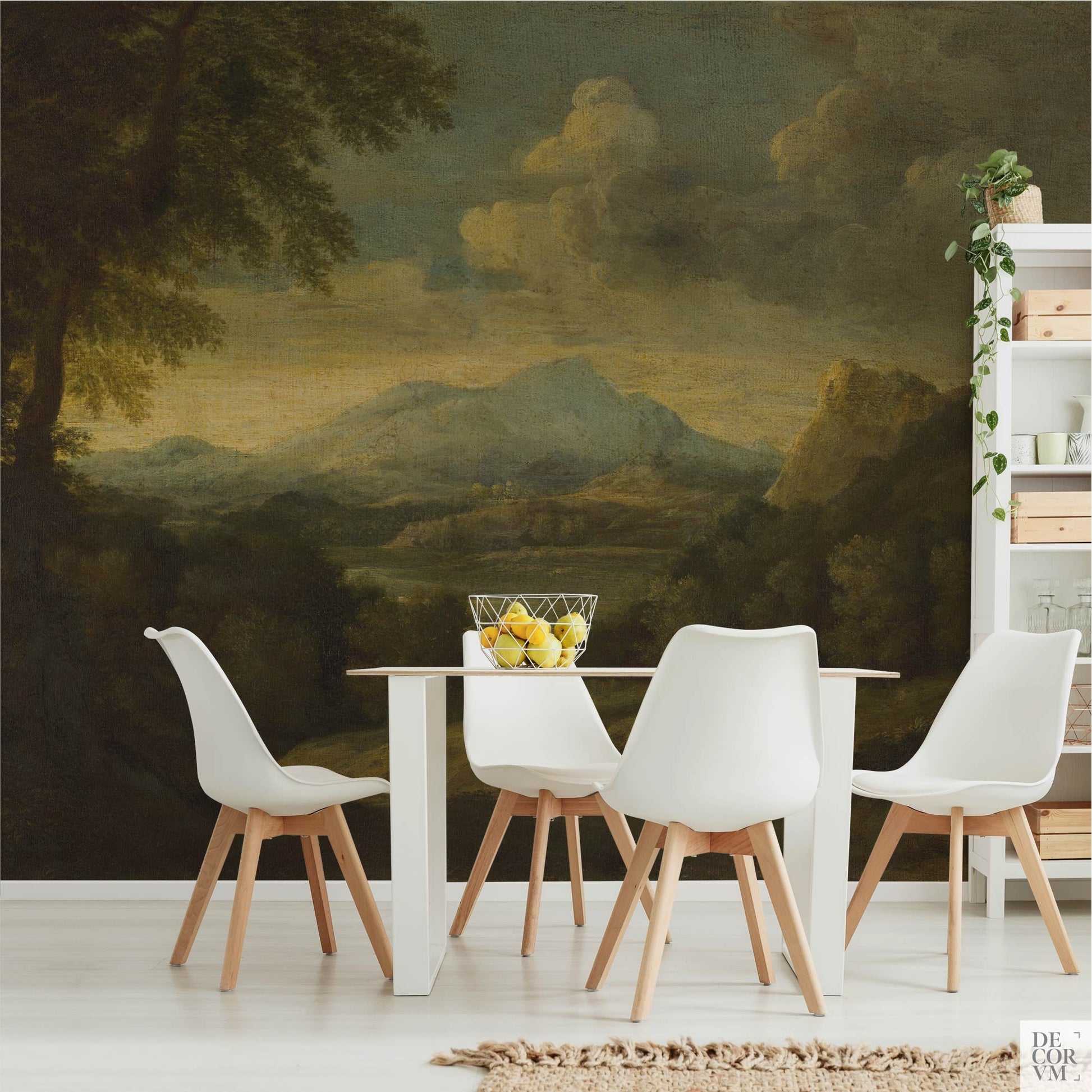 White dining chairs and a table set against the Moody Mountain Landscape Wallpaper Mural — Dark Academia Decor, alongside a white open shelving unit holding plants and decor.